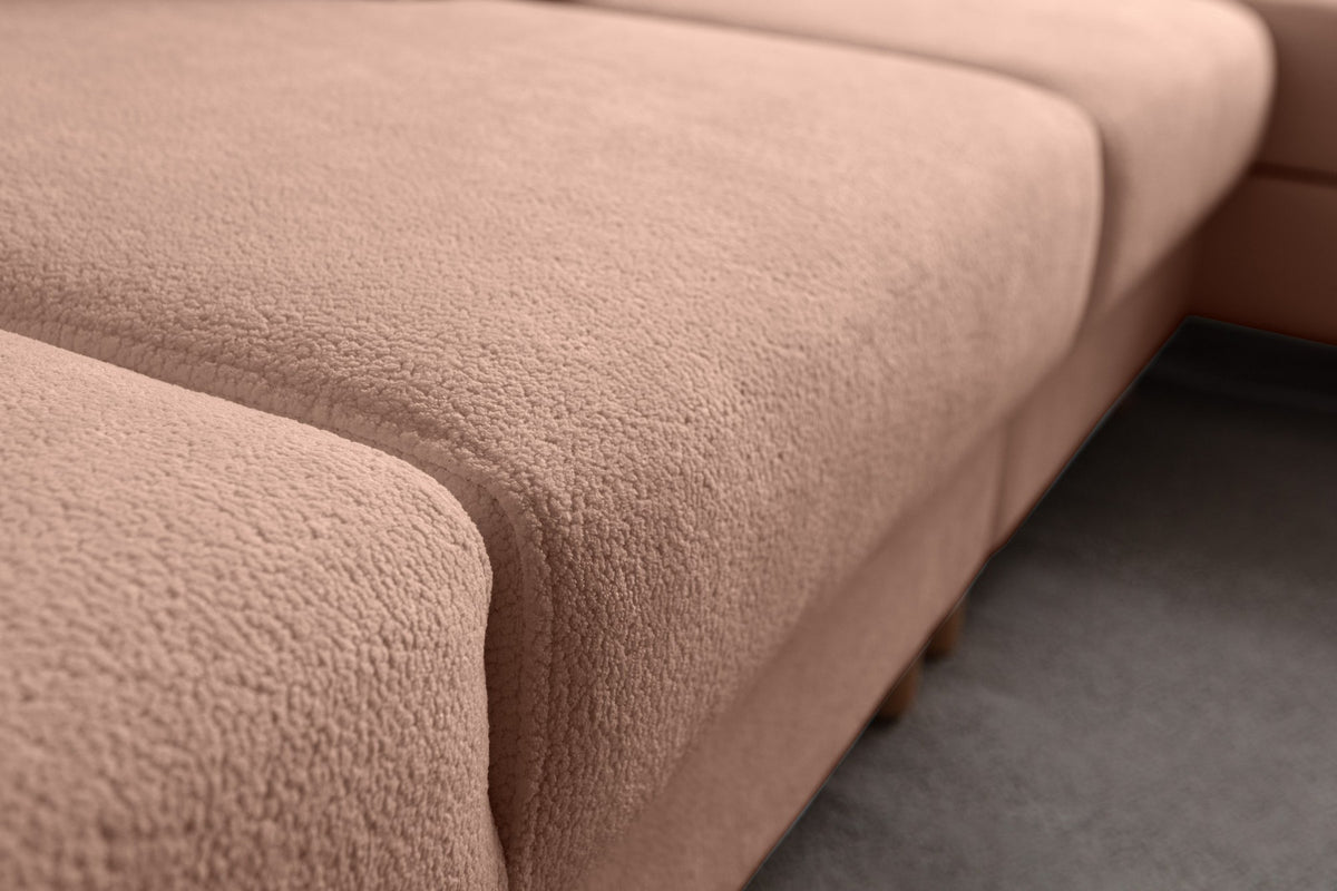 Eck-Schlafsofa Aries Relax Joker in Altrosa mit Coco-Boucle-Stoff, Holzbeinen und verstellbarer Rückenlehne, fotografiert im Wohnraum.