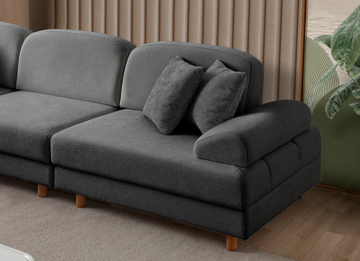Anthrazitfarbenes Eck-Schlafsofa mit Coco-Boucle-Stoff, Holzbeinen und vier Kissen, teilweise als Liegefläche ausgeklappt dargestellt.