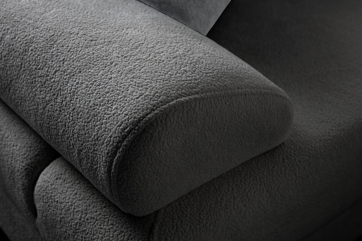 Anthrazitfarbenes Eck-Schlafsofa mit Coco-Boucle-Stoff, Holzbeinen und vier Kissen, teilweise als Liegefläche ausgeklappt dargestellt.
