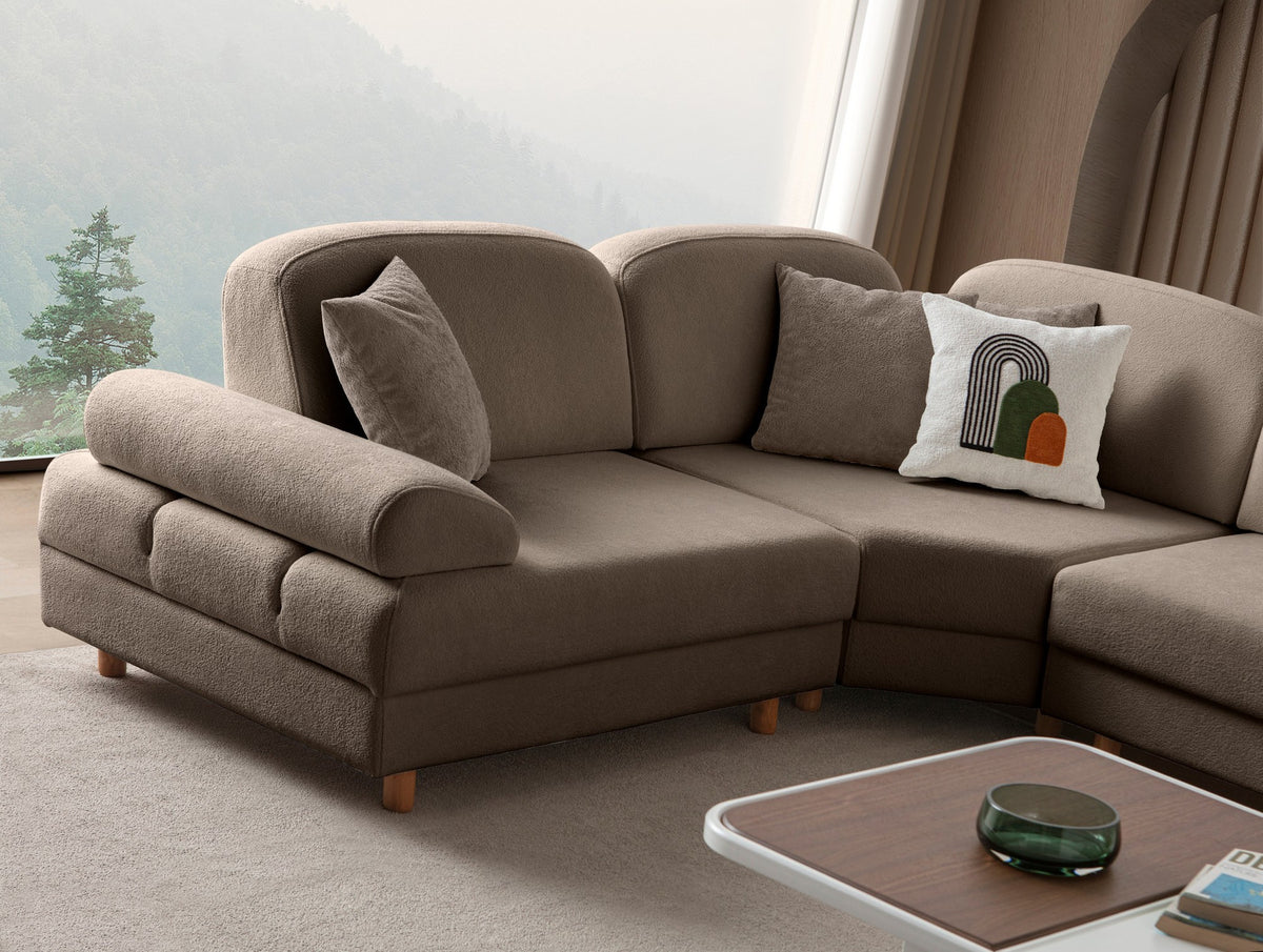 Braunes Eck-Schlafsofa Aries Modular S von Hanah Home mit Coco-Boucle-Stoff, Holzbeinen und vier Kissen in einem Wohnzimmer.