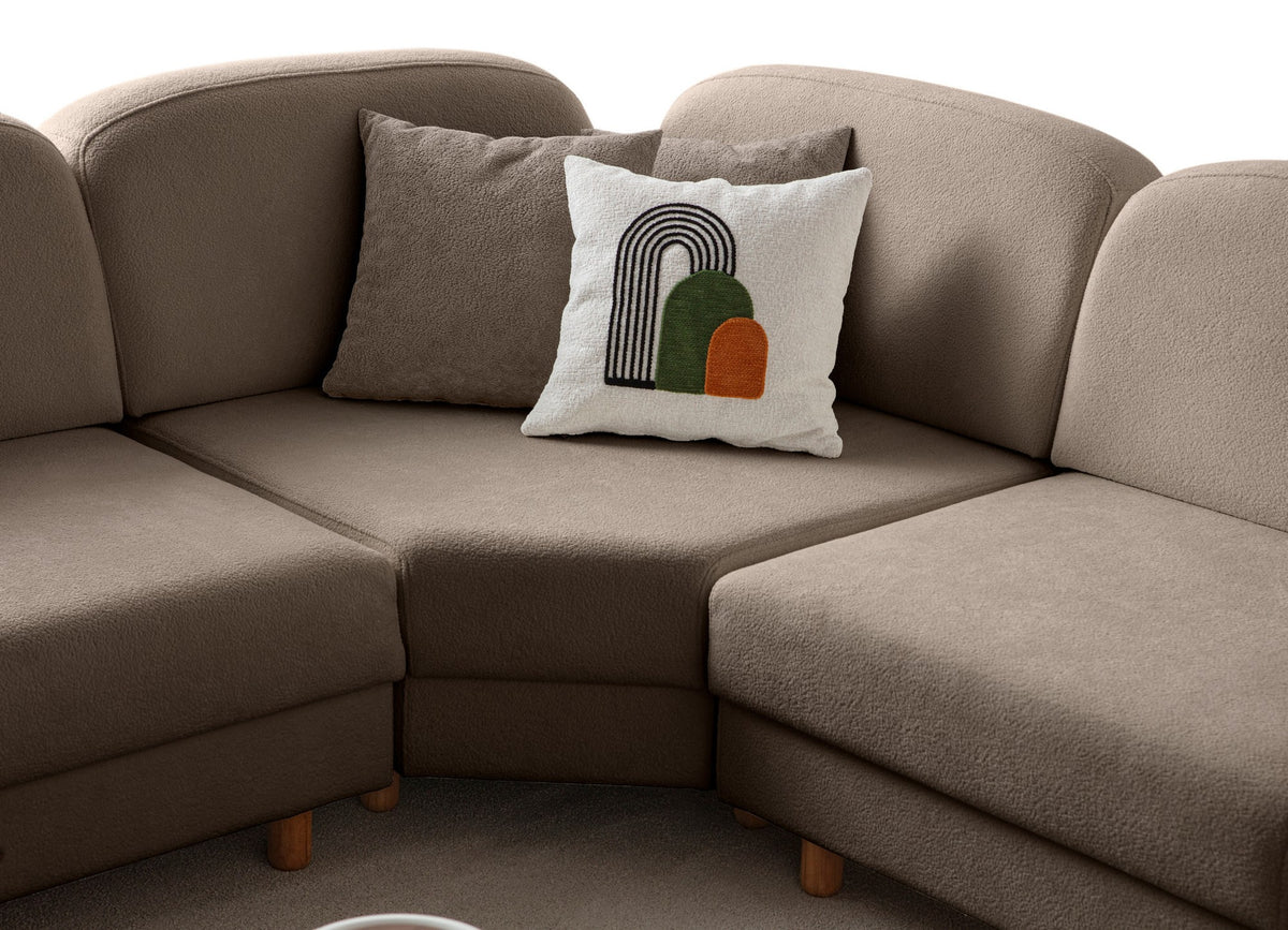 Braunes Eck-Schlafsofa Aries Modular S von Hanah Home mit Coco-Boucle-Stoff, Holzbeinen und vier Kissen in einem Wohnzimmer.