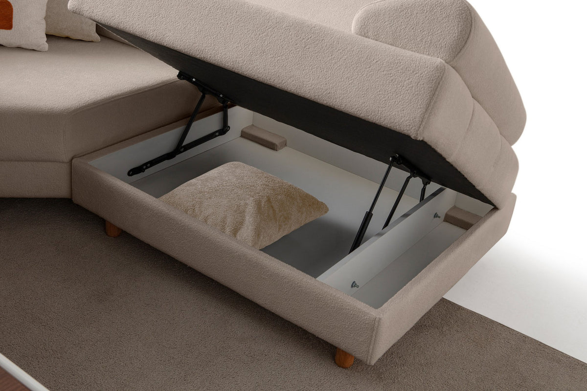 Eckschlafsofa Aries Modular S in Milchkaffee mit Coco-Boucle-Stoff, Holzbeinen und vier Kissen, fotografiert im Wohnraum.