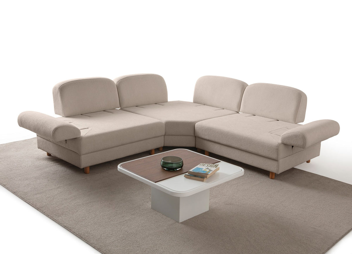 Eckschlafsofa Aries Modular S in Milchkaffee mit Coco-Boucle-Stoff, Holzbeinen und vier Kissen, fotografiert im Wohnraum.