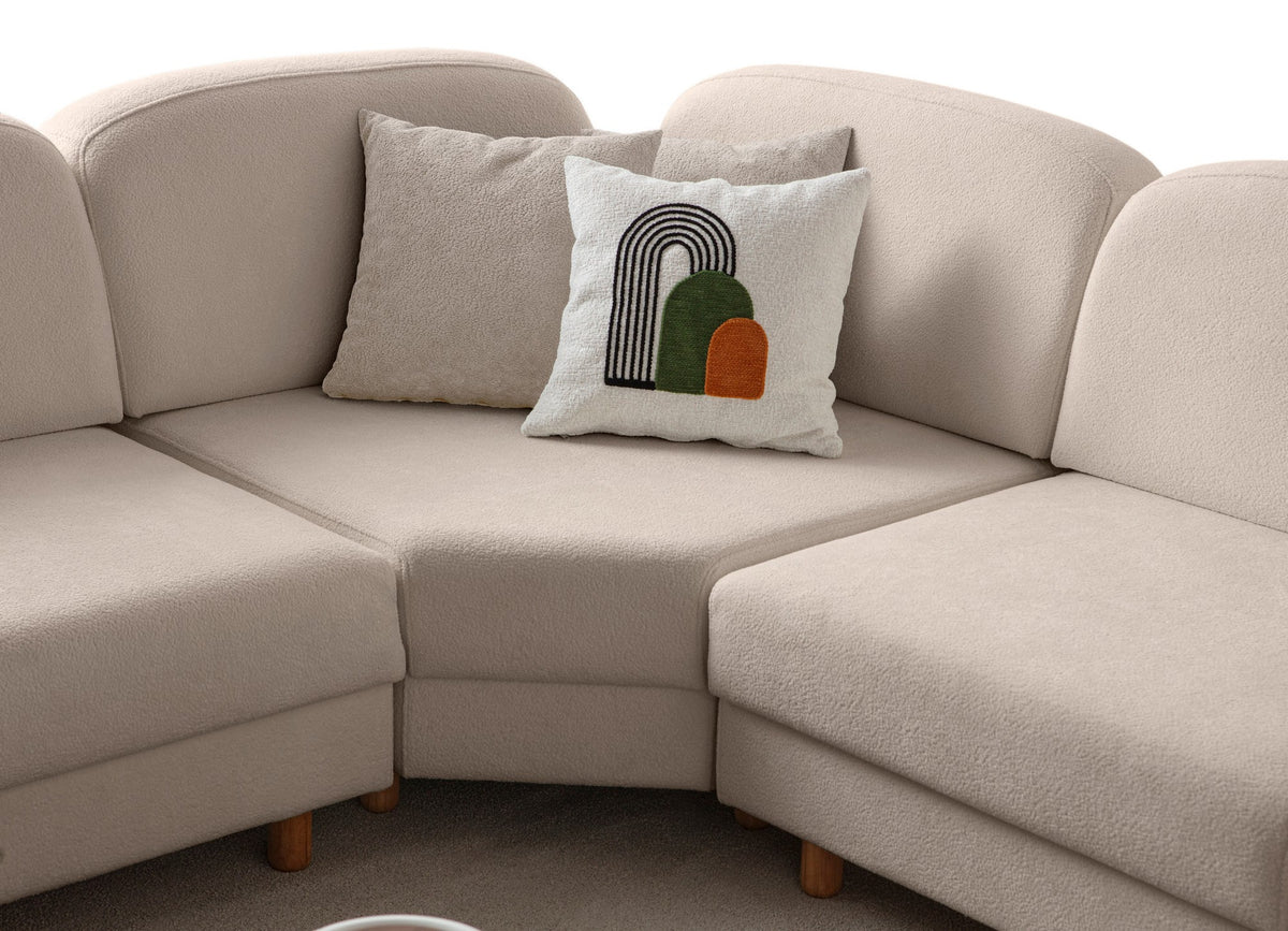 Eckschlafsofa Aries Modular S in Milchkaffee mit Coco-Boucle-Stoff, Holzbeinen und vier Kissen, fotografiert im Wohnraum.