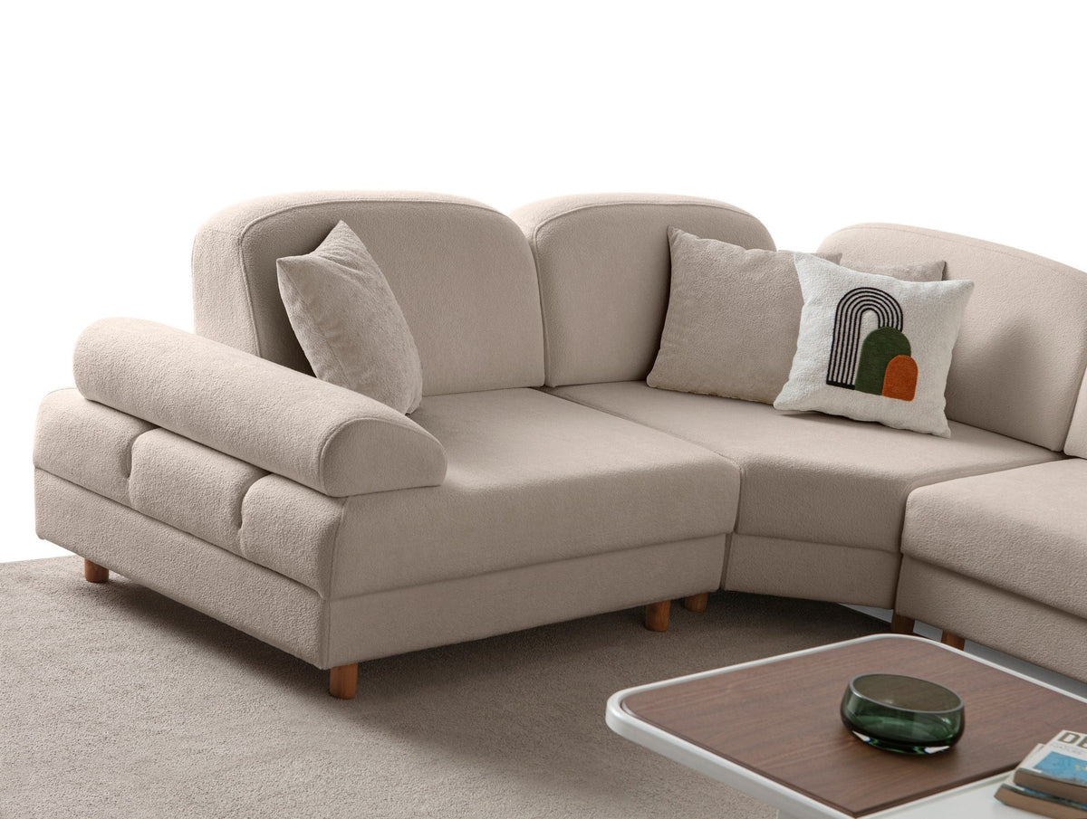 Eckschlafsofa Aries Modular S in Milchkaffee mit Coco-Boucle-Stoff, Holzbeinen und vier Kissen, fotografiert im Wohnraum.