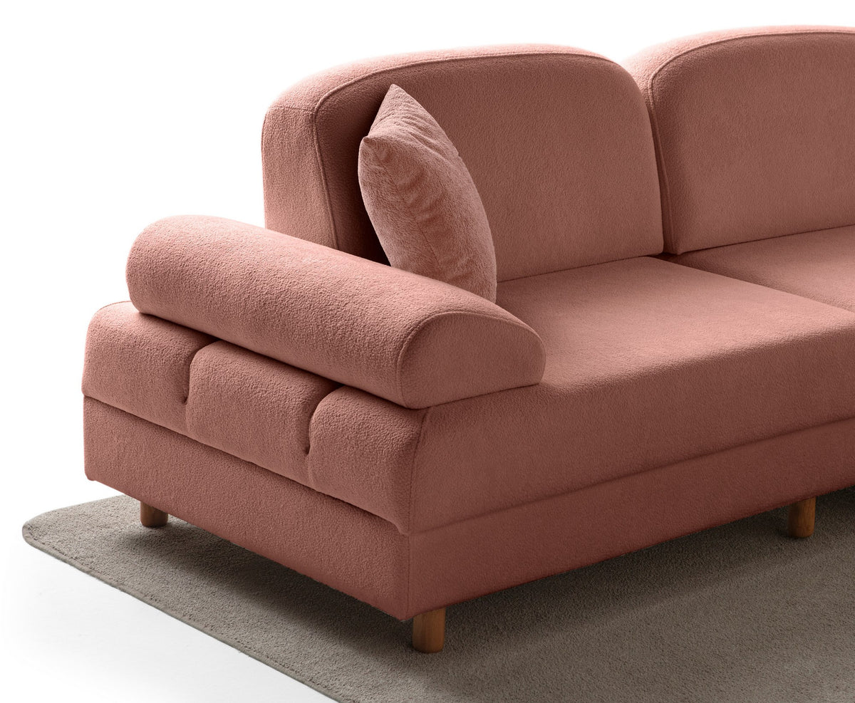 Modulares Eck-Schlafsofa in Altrosa mit Boucle-Stoffbezug, Holzbeinen und vier Kissen, fotografiert aus frontaler Perspektive.
