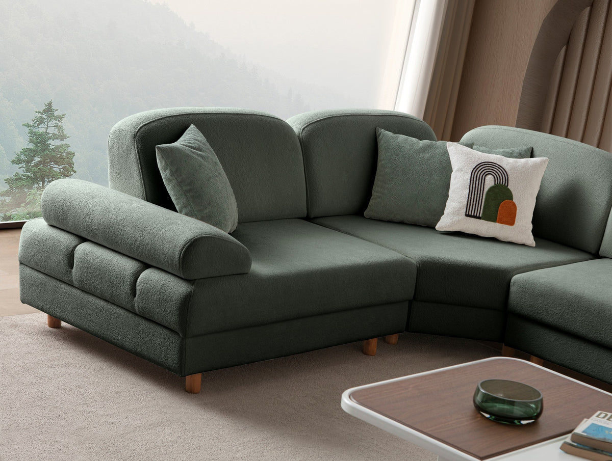 Grünes Eck-Schlafsofa Aries Modular M von Hanah Home mit Coco-Boucle-Polyesterbezug, Holzbeinen und sechs Zierkissen im Wohnzimmer.