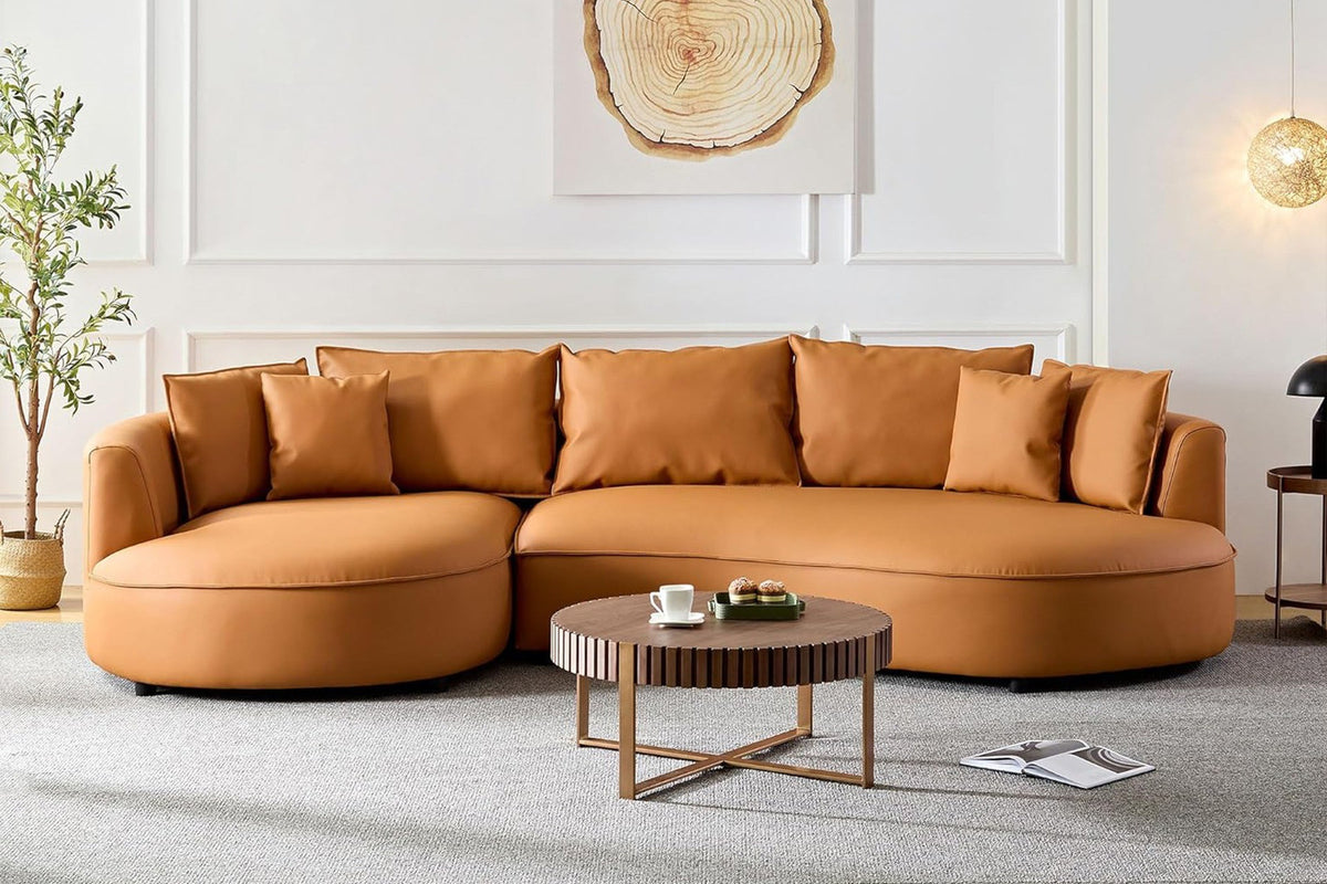 Orangefarbenes Ecksofa Venedik links von Hanah Home mit glattem Kunstlederbezug, Kunststoffbeinen und sieben mitgelieferten Kissen.