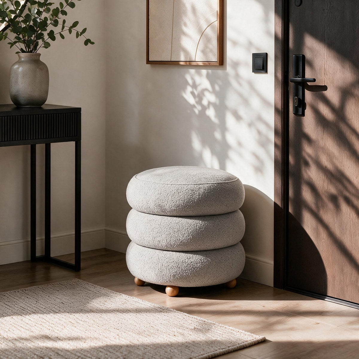 Hellgrauer Ottavia Pouf von Hanah Home mit gestricktem Polyesterbezug, gepolsterter Sitzfläche und Kugelfüssen aus Holz in kompakter Kubusform.