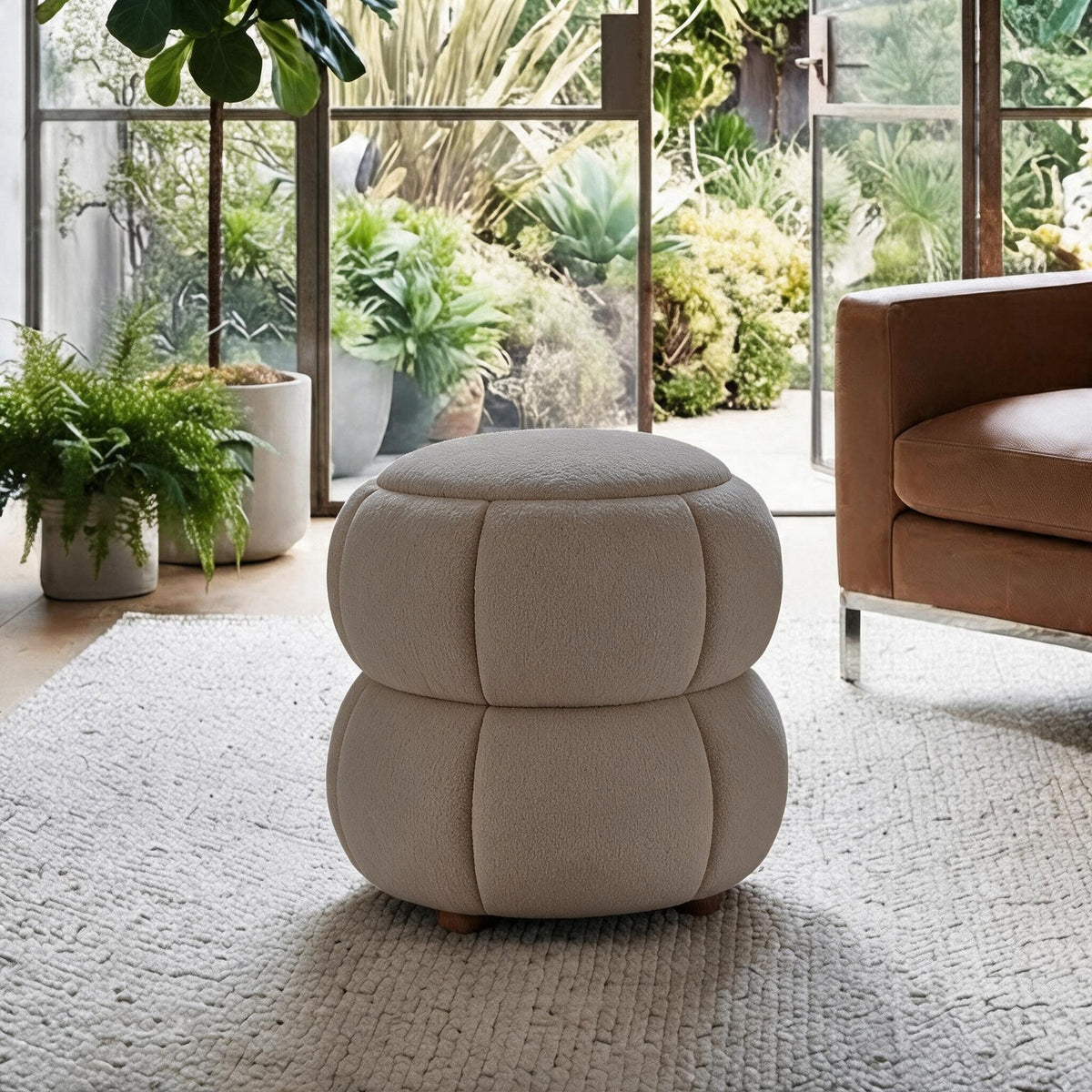 Softura Pouf in Latte von Hanah Home, rundes Sitzmöbel mit gestricktem Polyesterbezug und Holzkugelfüssen, frontale Ansicht auf hellem Untergrund.