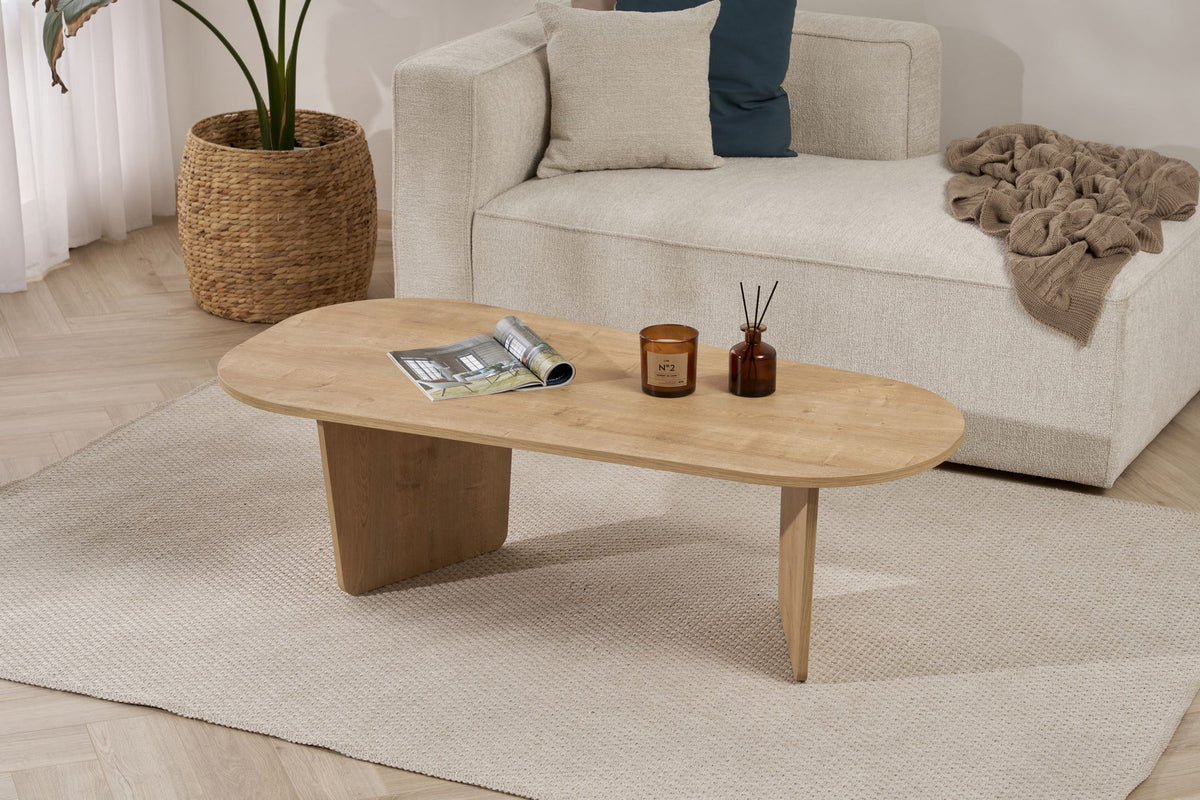 Couchtisch Ovalis von Nordure in Eiche-Optik, Tischplatte aus melaminbeschichteter Spanplatte, Masse 130x65x40 cm, freistehend im Raum.