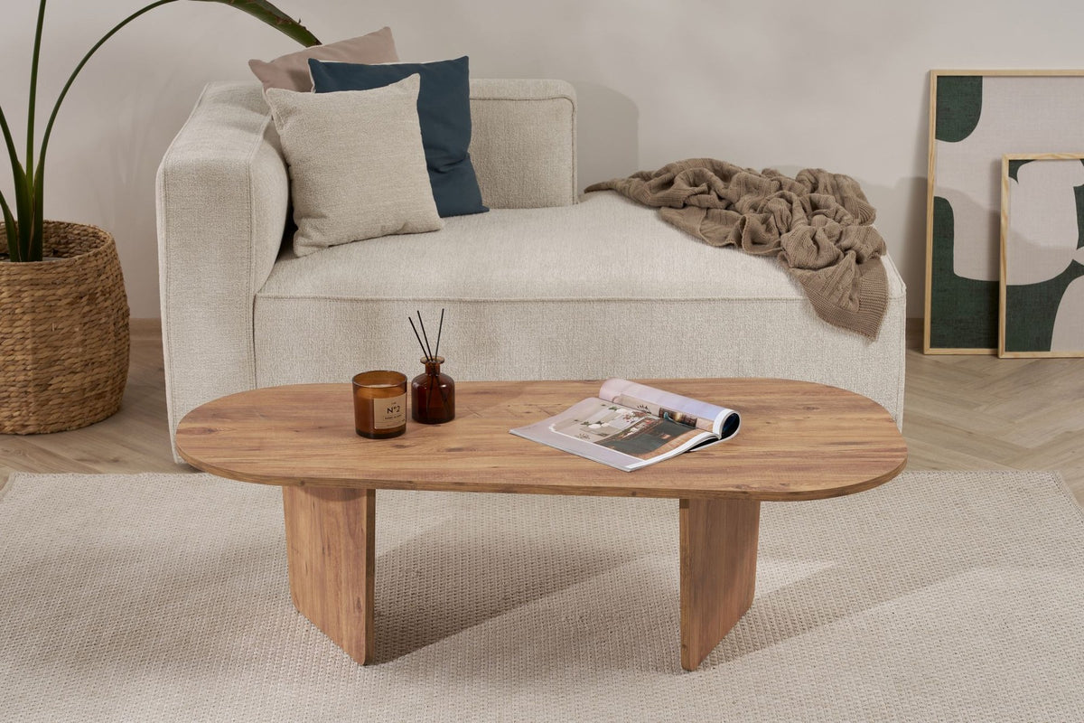 Ovaler Couchtisch in Atlantik-Kiefer Optik von Nordure aus melaminbeschichteter Spanplatte, 130 cm breit, 65 cm tief, 40 cm hoch, im Wohnraum platziert.