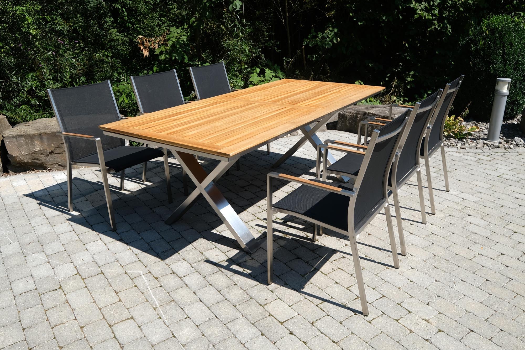 Eleganter Gartentisch Monaco mit X-Form und hochwertiger Teakplatte, ideal für stilvolle Outdoor-Bereiche.