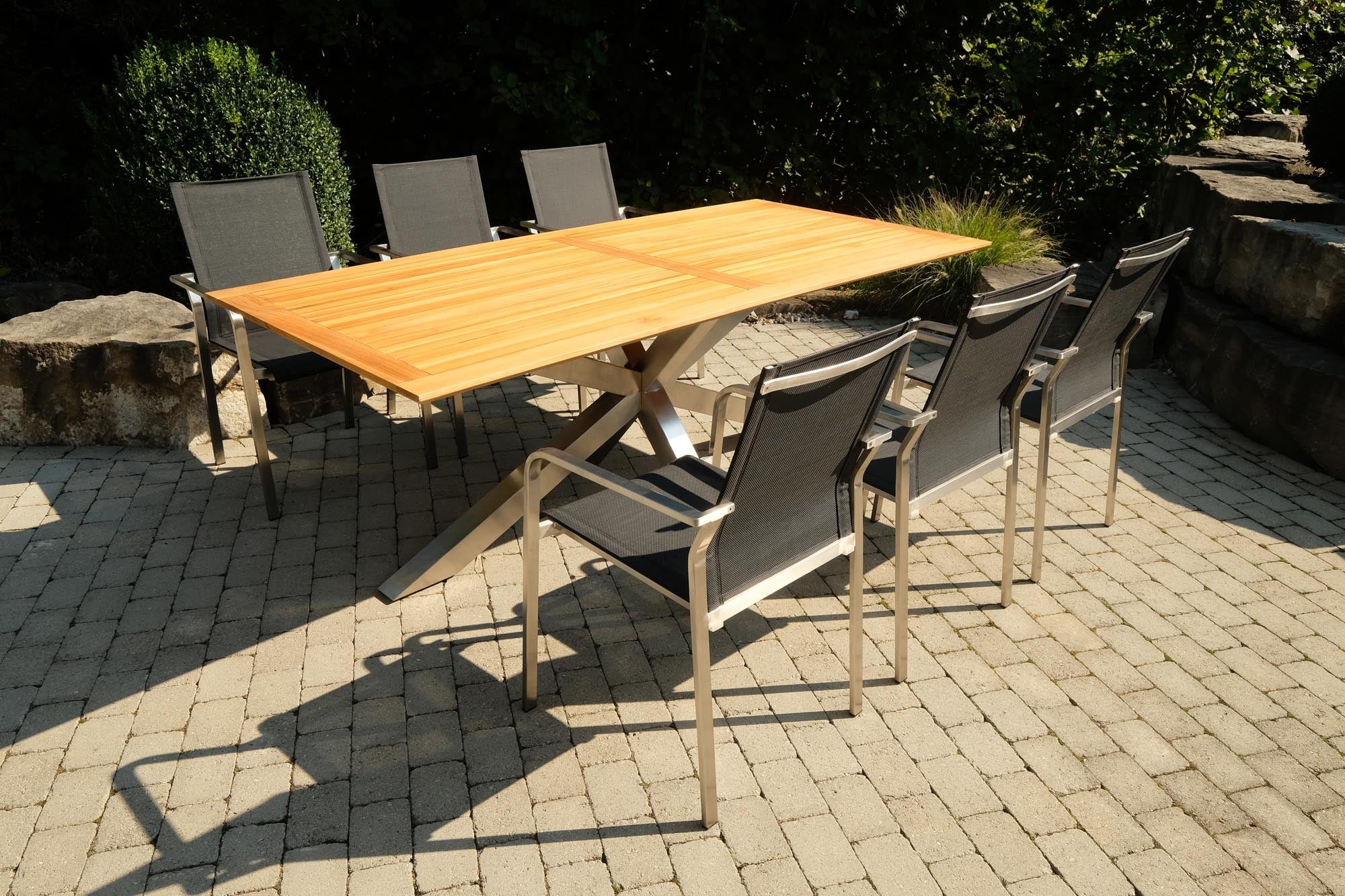 Eleganter Gartentisch Monaco mit stabilen XX-Füßen und hochwertiger Teakplatte, ideal für stilvolle Outdoor-Bereiche.