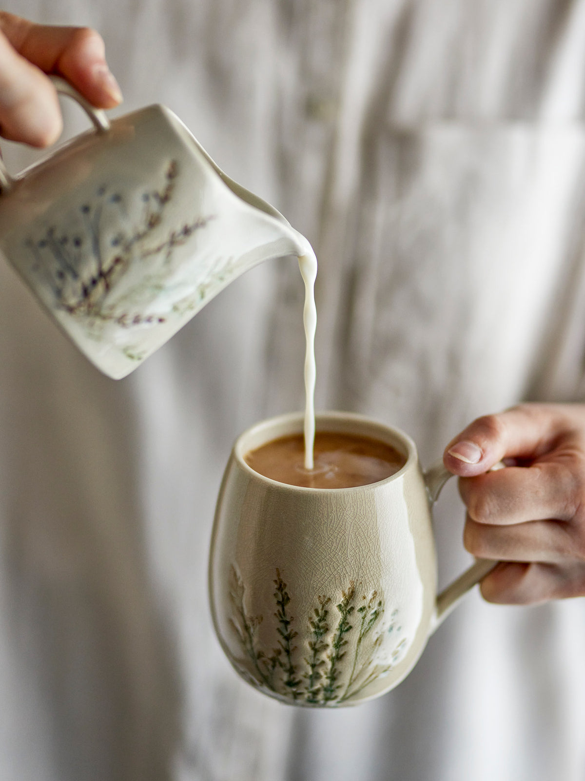 Weisse Tasse Bea aus Steingut mit zartem Blumenmuster und feiner Krakeleeglasur