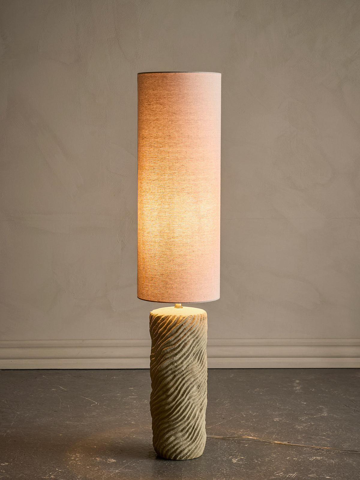 Stehlampe Payah in Beige von Bloomingville mit Fuss aus strukturiertem Steingut, Gestell aus Eisen und rundem Lampenschirm aus Polyester.