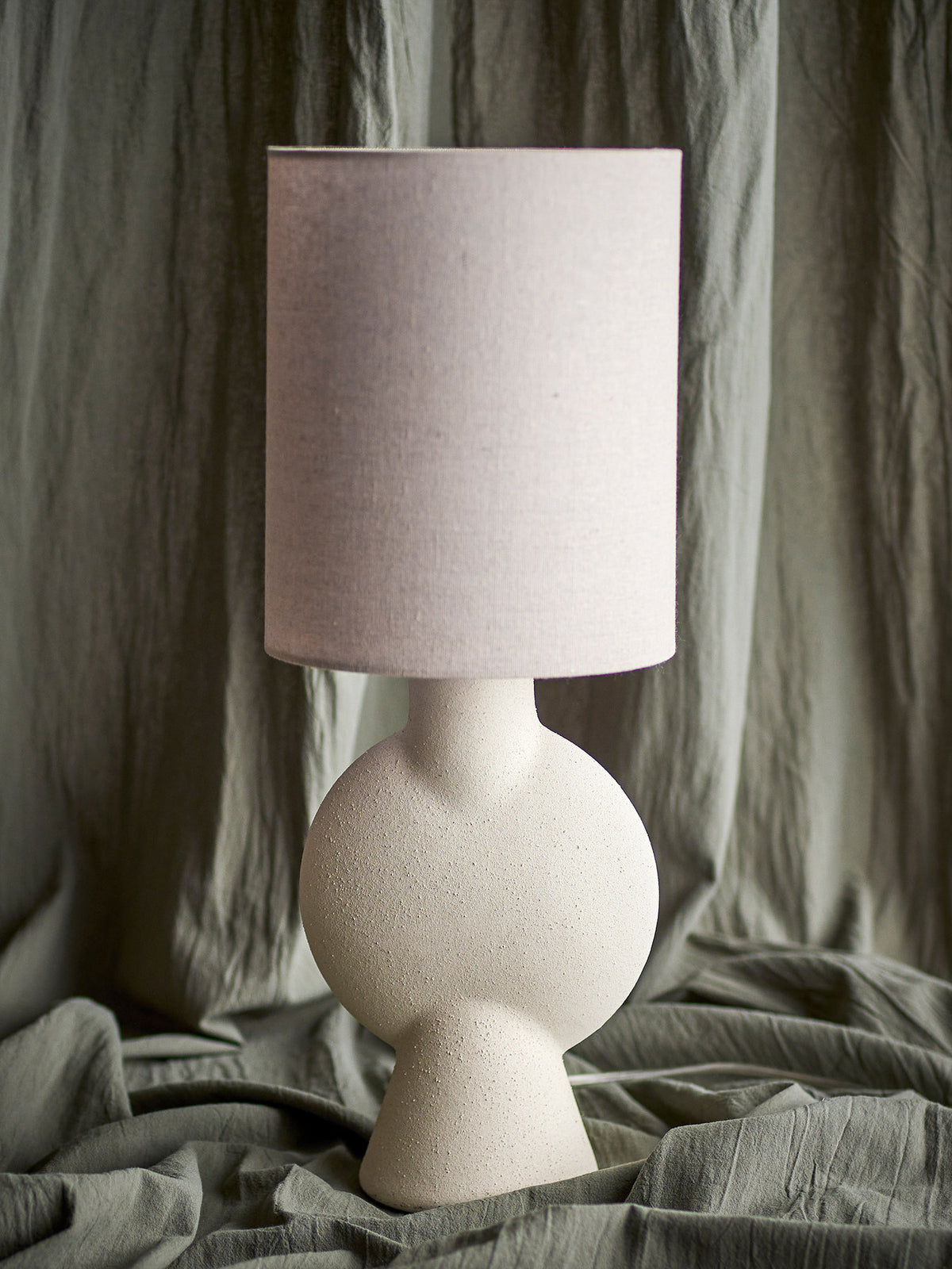 Weisse Tischlampe Sergio von Bloomingville aus Steingut mit rundem Fuss, schmalem Hals und Leinenschirm, Höhe 55 cm, Durchmesser 21 cm.