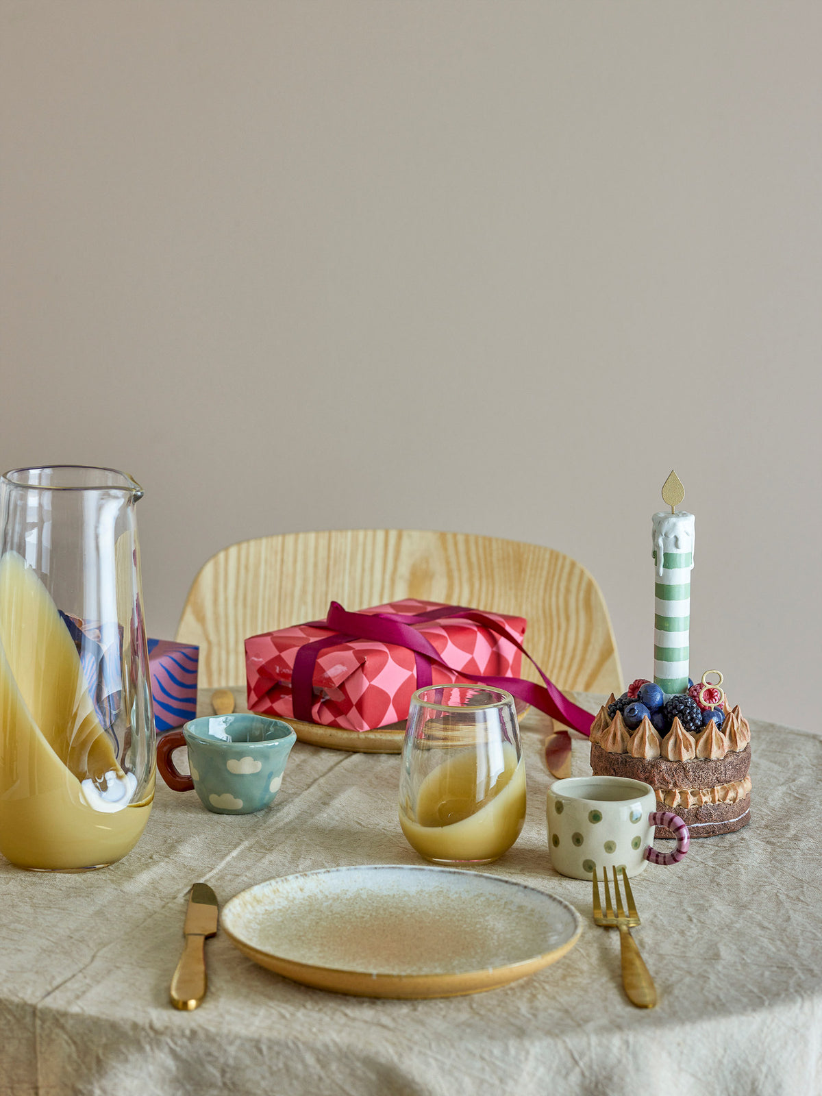 Weisse Nini Tasse aus Steingut von Bloomingville mit handbemaltem Muster, kleine runde Form mit Henkel, auf hellem Hintergrund fotografiert.