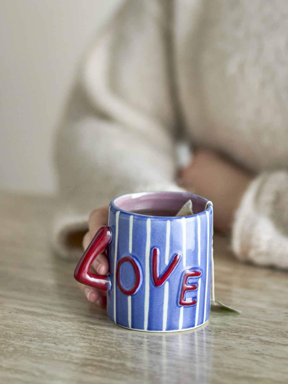 Blauer Cherish Becher aus Steinzeug mit weissen vertikalen Streifen, rotem Henkel und handbemalten Schriftzügen 'Love' und 'More' von Bloomingville.