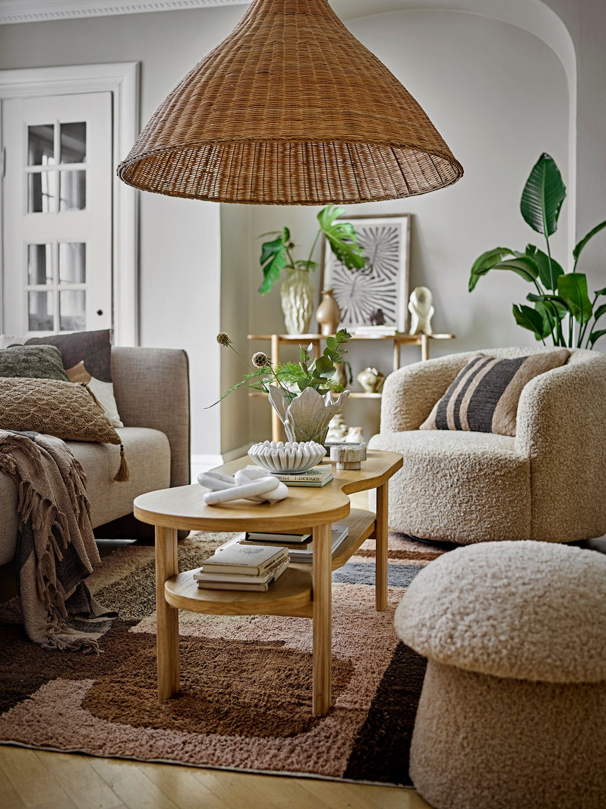 Runder Pouf in Beige mit strukturierter Polyester-Oberfläche und Beinen aus Kiefernholz, breite Oberseite über schmalerem Fuss.