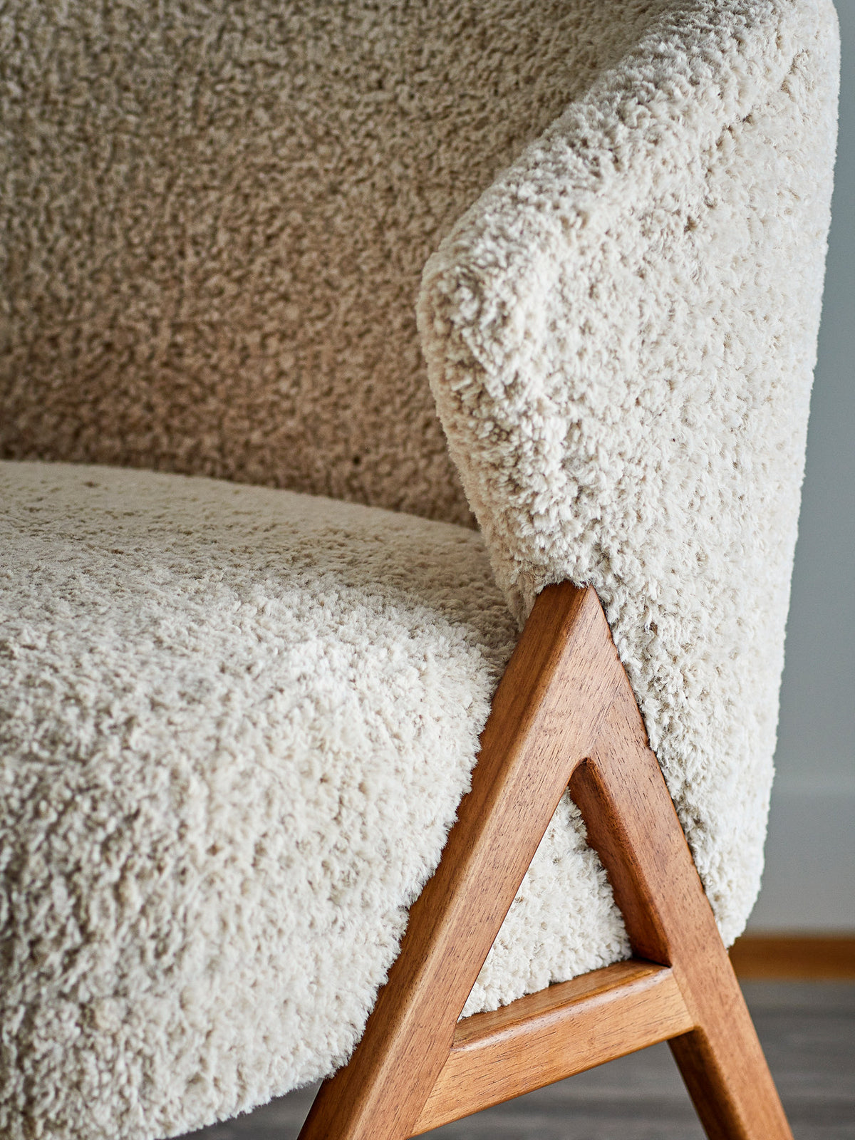 Beiger Camino Loungesessel mit Teddyfleece-Bezug und braunen lackierten Holzbeinen