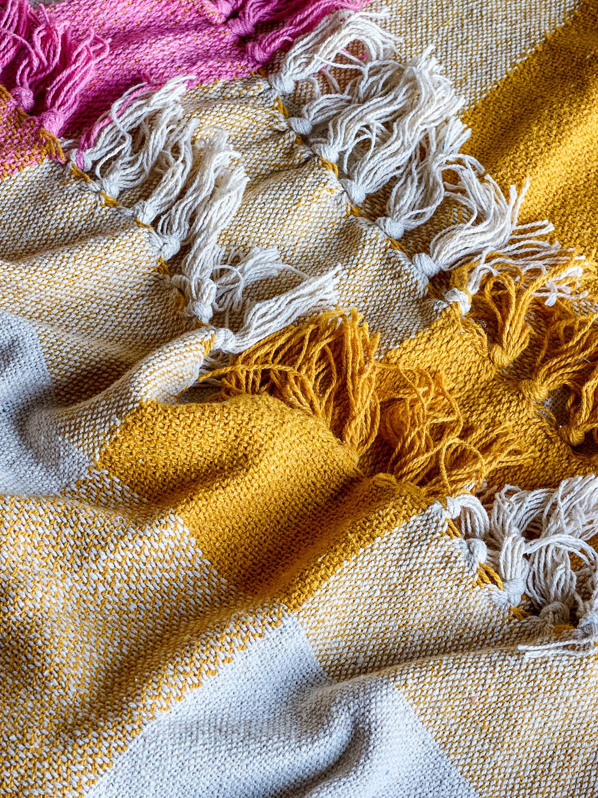 Gewobene Hadley Decke in Bunt aus Mischfasern mit Karomuster und dekorativen Fransen, Grösse 160 x 130 cm, als Bettüberwurf drapiert.