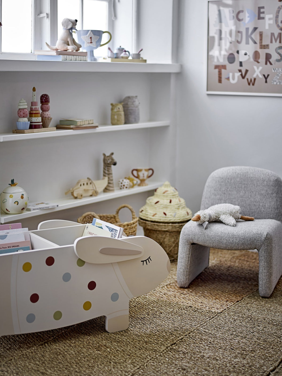 Buntes Bücherregal aus MDF in Kaninchenform mit weissen Beinen, offenes Fach für Bücher und Spielzeug im Kinderzimmer.