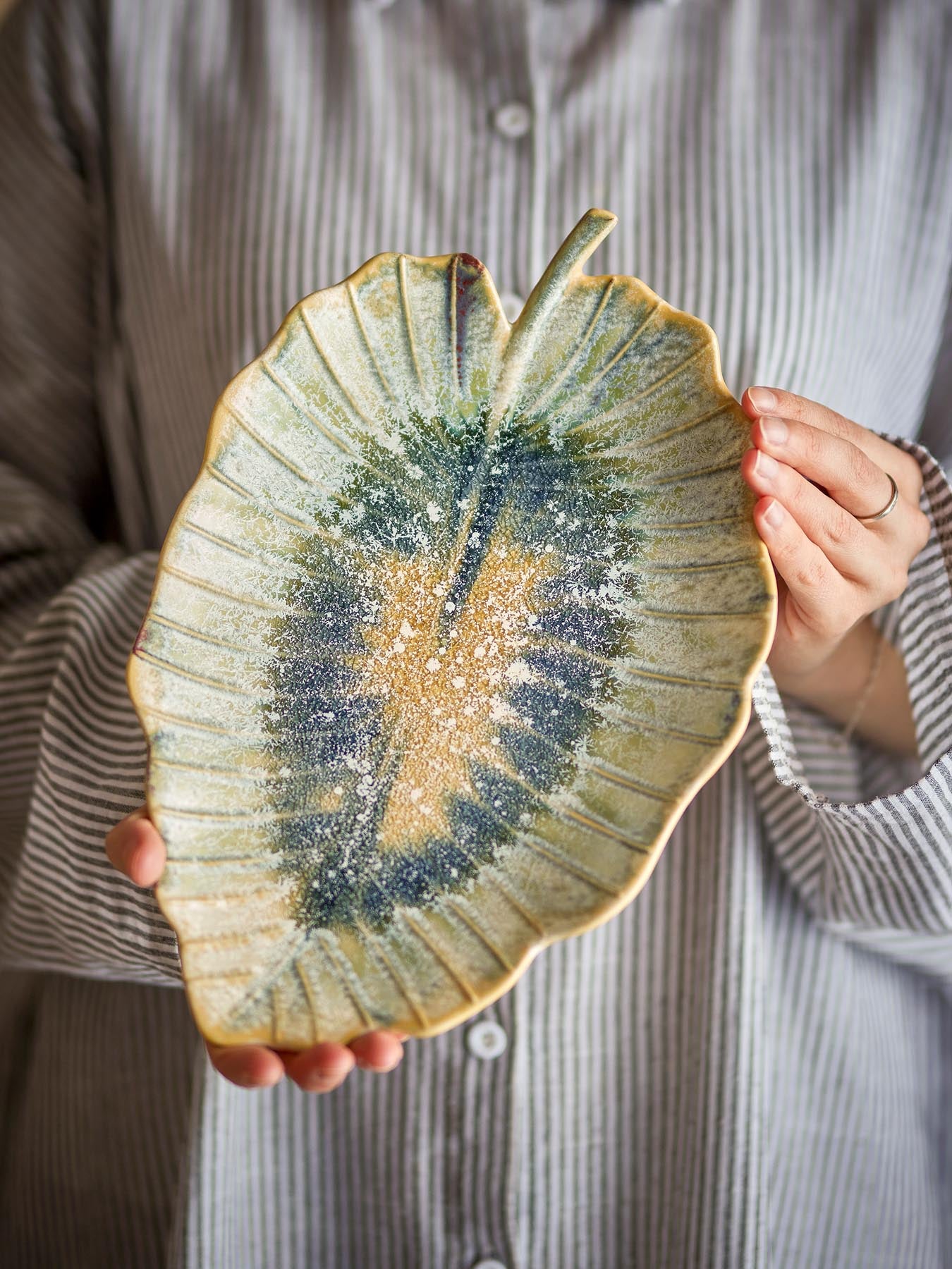 Verleihen Sie Ihrem Tisch mit der Dorreen Servierplatte aus robustem Steingut in faszinierenden Blau- und Grüntönen einen Hauch von Eleganz.