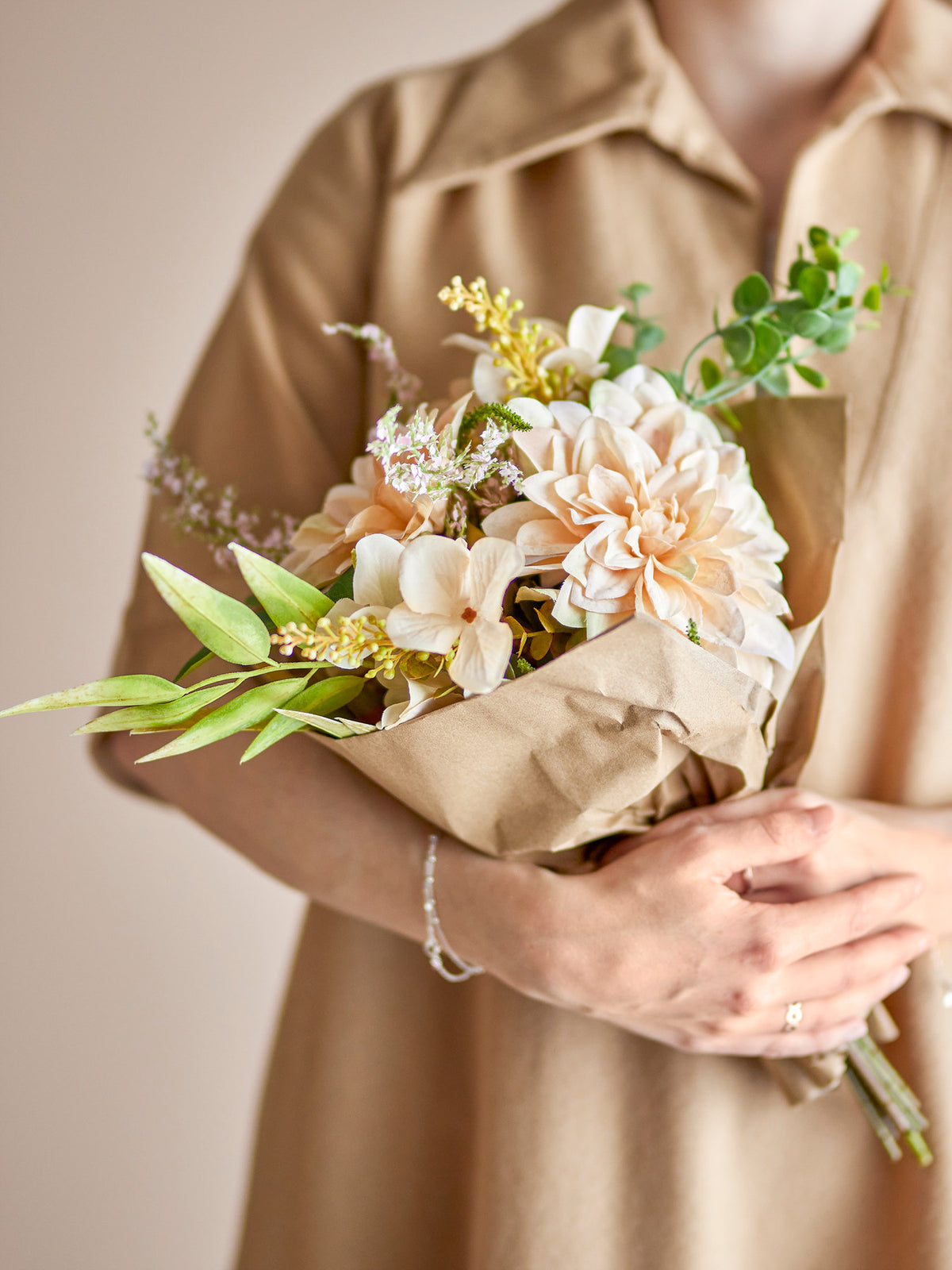 Glow Blumenstrauss in Beige von Bloomingville: künstliche Blumen mit zentraler Chrysantheme, umgeben von Blättern und Blüten, kompakte Form für kleine Vasen.