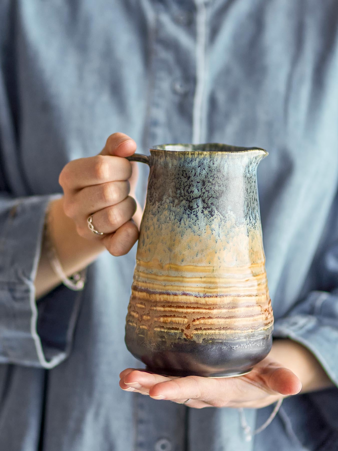 Entdecken Sie den einzigartigen Deana Krug von Bloomingville aus hochwertigem Steingut. Mit seiner eleganten, reaktiven Glasur in Blau und individuellen Farbtönen ist er ein stilvolles Highlight für Ihr Zuhause.