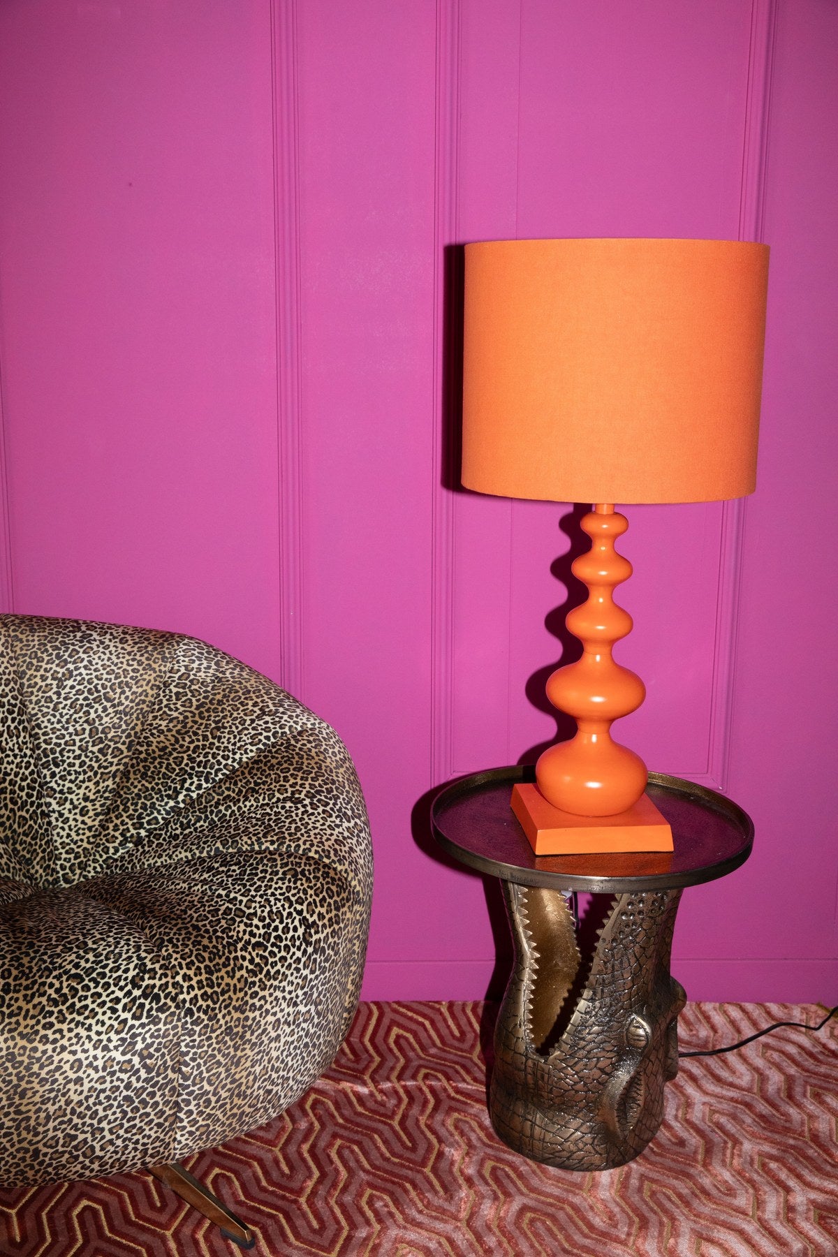 Stehlampe von Bold Monkey aus Eisen in leuchtendem Orange, geschwungene Form, mit E27-Fassung, Höhe 78 cm, für den Innenbereich.