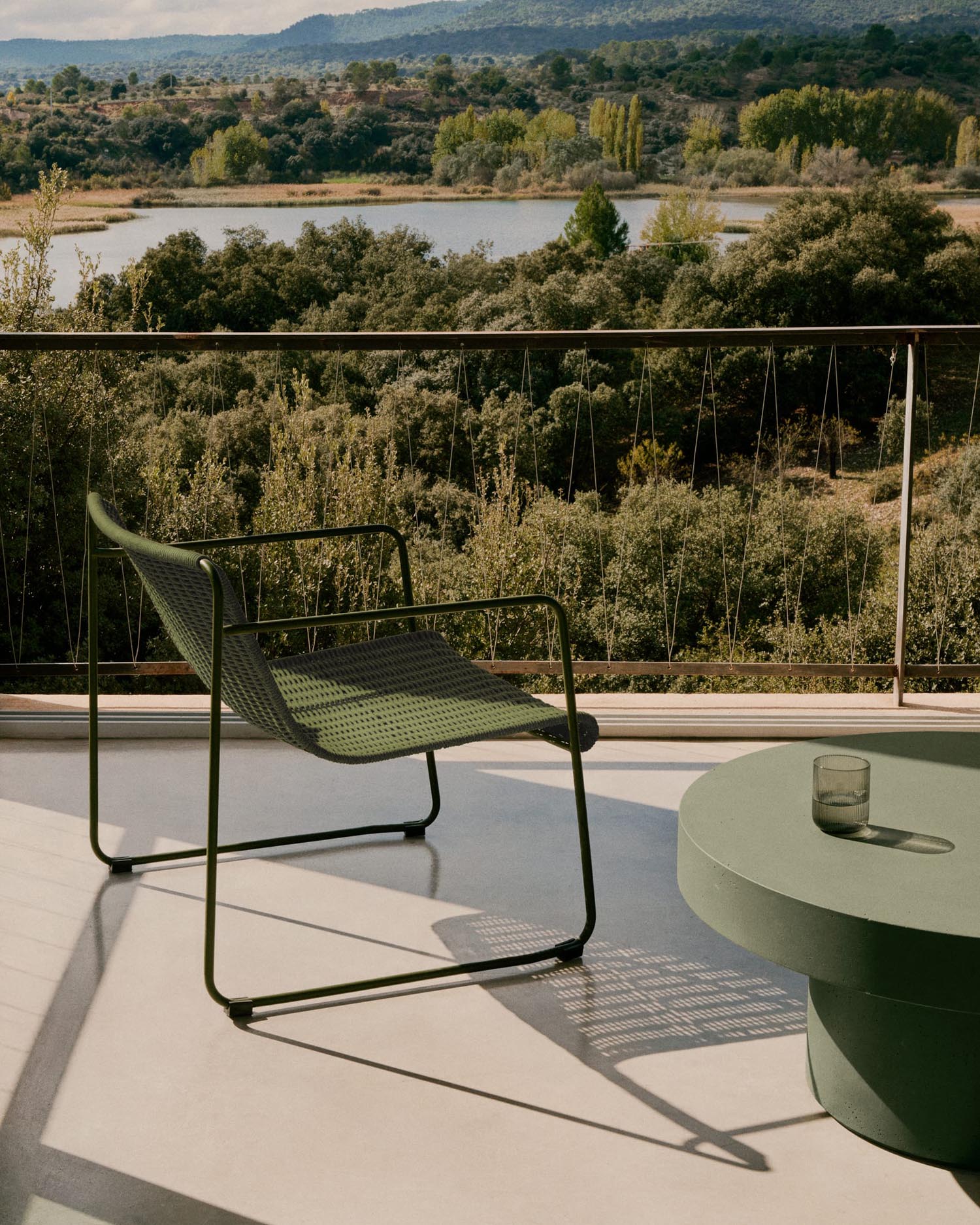 Eleganter Sessel aus grünem Stahl und Seil, wetterfest und bequem, ideal für stilvolle Outdoor-Bereiche.