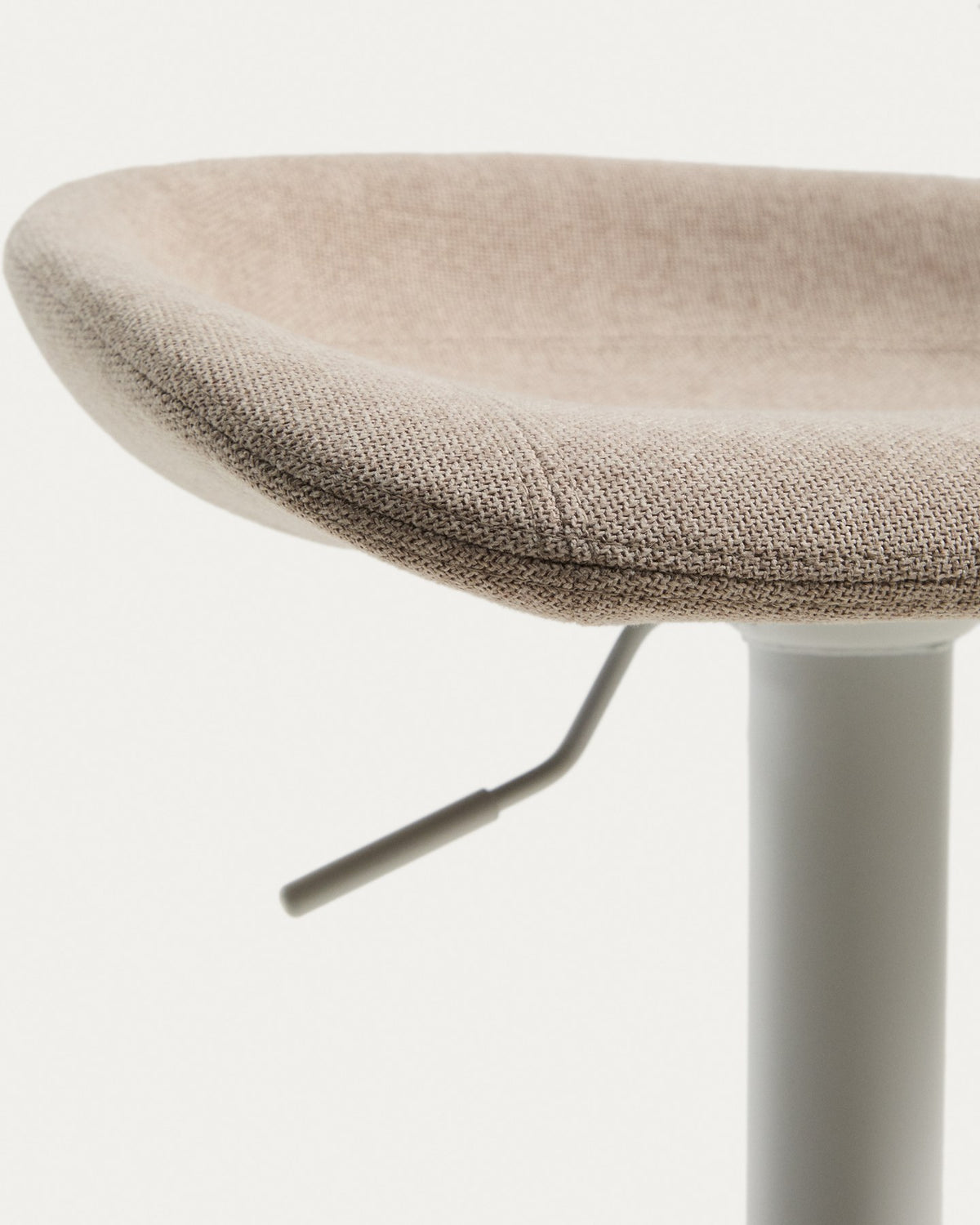 Runder Hocker mit beigem Chenillebezug, gepolstertem Sitz und mattweissem Stahlgestell mit rundem Fussring, freigestellt fotografiert.