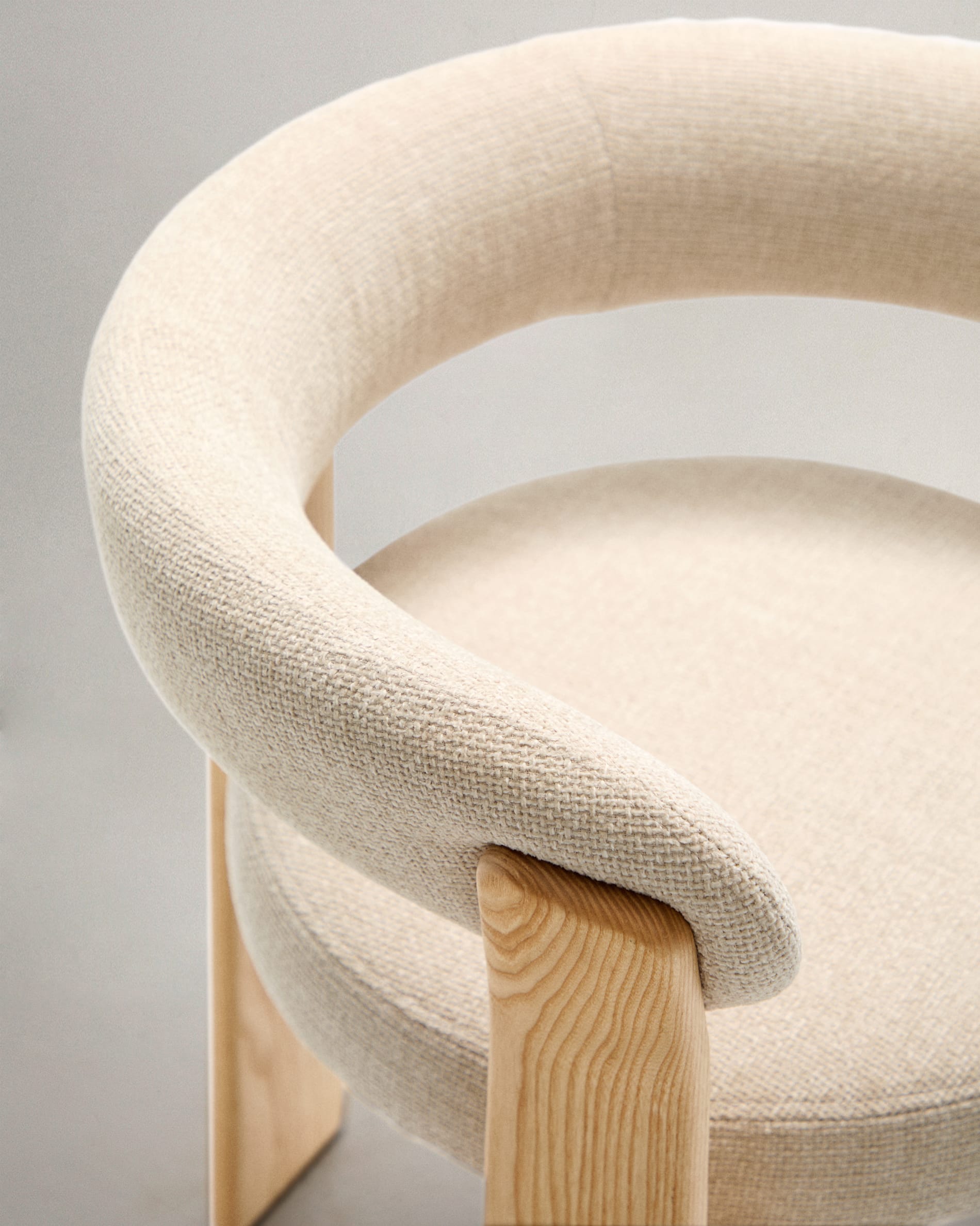 Eleganter 3-beiniger Stuhl mit beiger Chenille-Polsterung, aus massivem Eschenholz mit natürlichem Finish, FSC-zertifiziert, von Kave Home.
