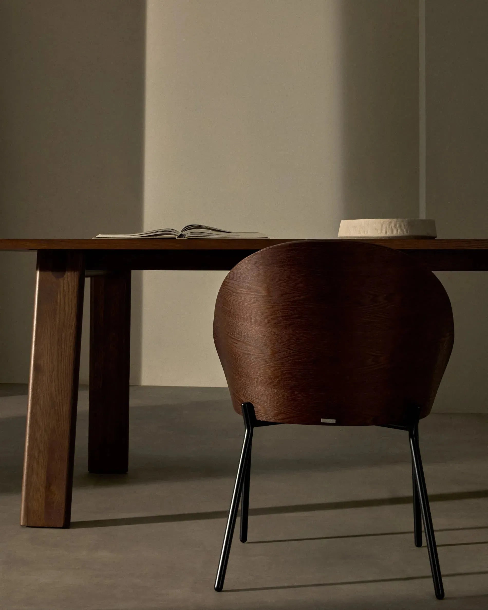 Eleganter Eamy Stuhl mit braunem Kunstleder, Nussbaum-Eschenfurnier und schwarzem Metallgestell, ideal für modernes Wohnen.