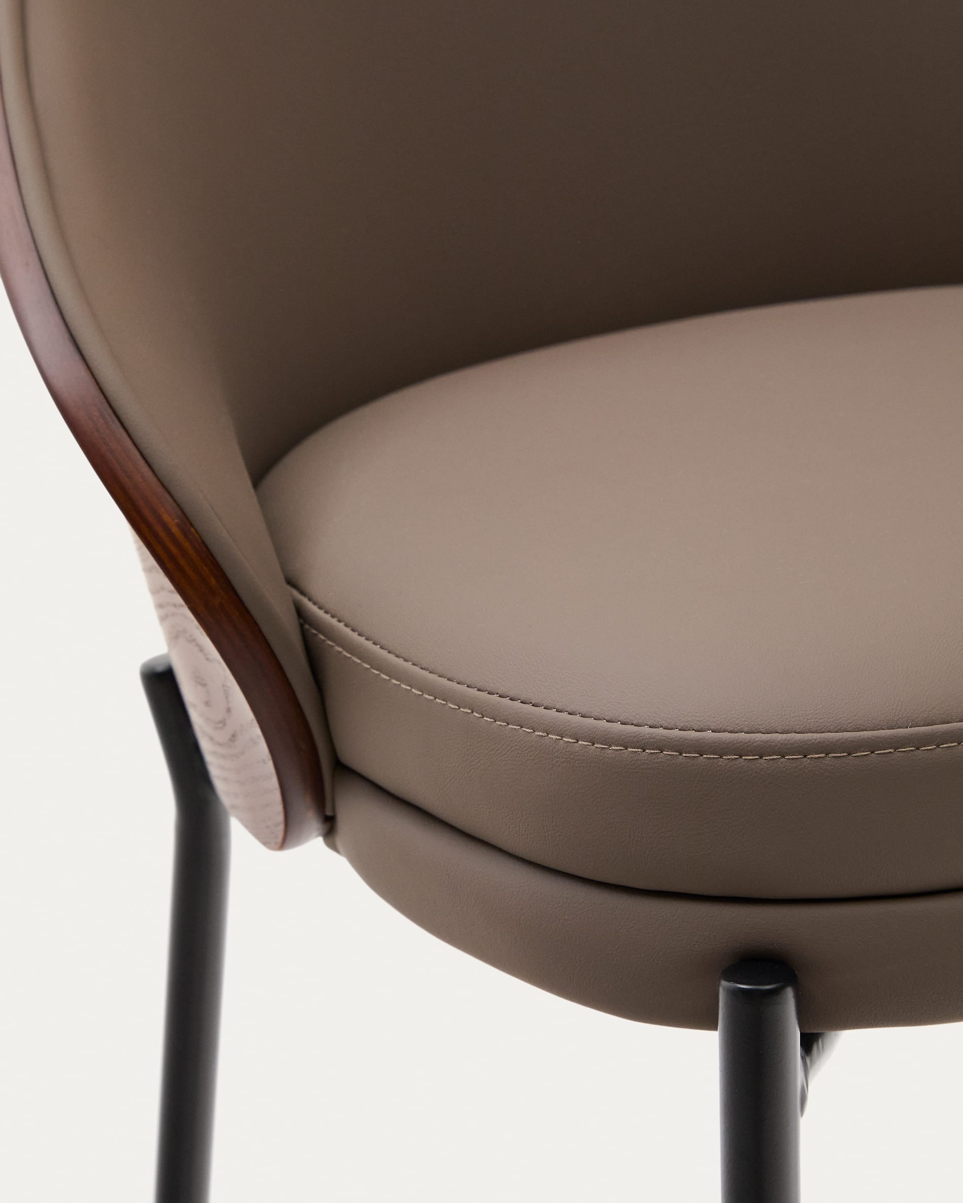 Moderner Hocker mit braunem Kunstleder, Nussbaum-Eschenfurnier und schwarzem Metall, perfekt für stilvolle Wohnräume.
