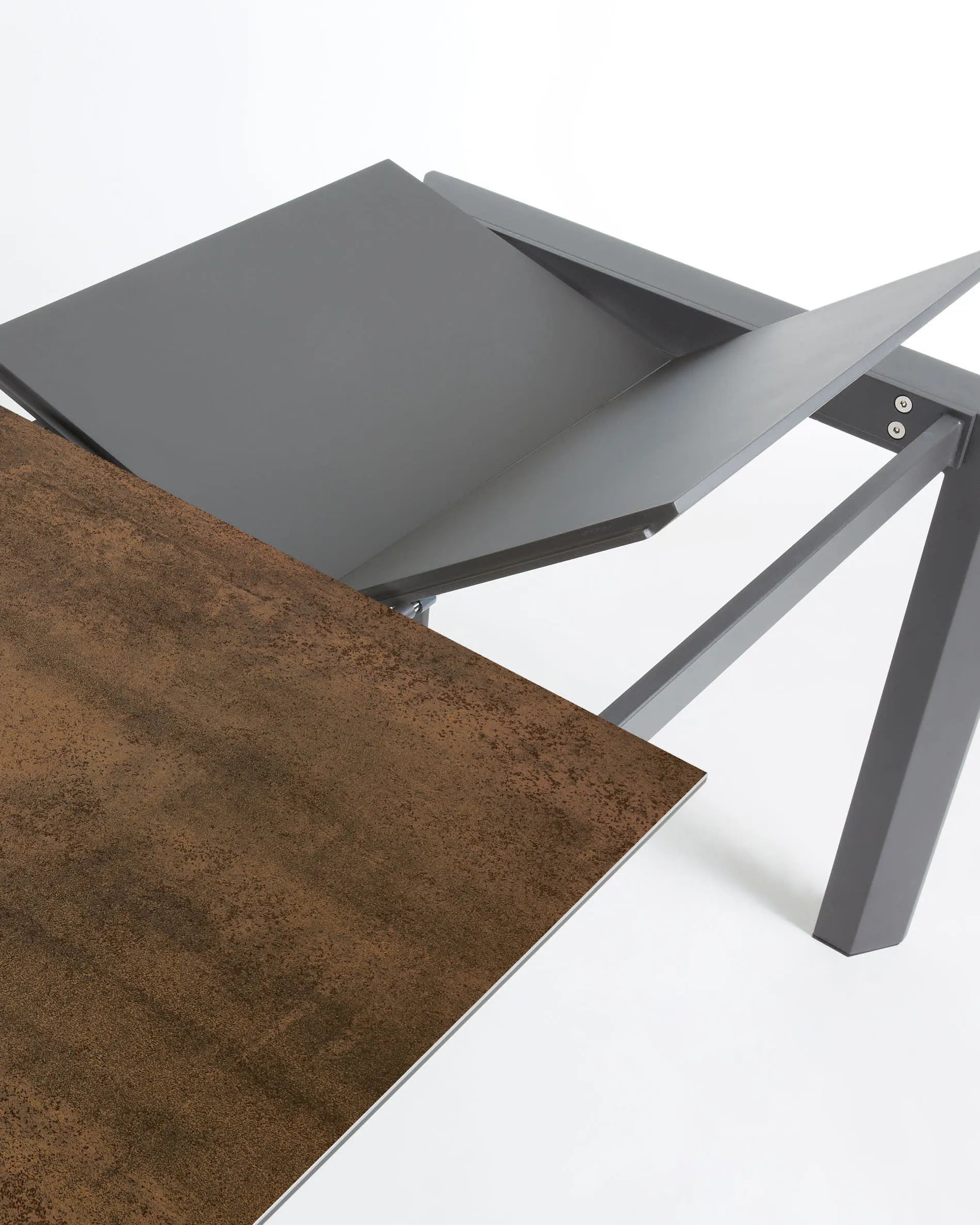 Moderner Ausziehtisch mit robuster Feinsteinzeugplatte im Iron Corten Finish und eleganten dunkelgrauen Metallbeinen.
