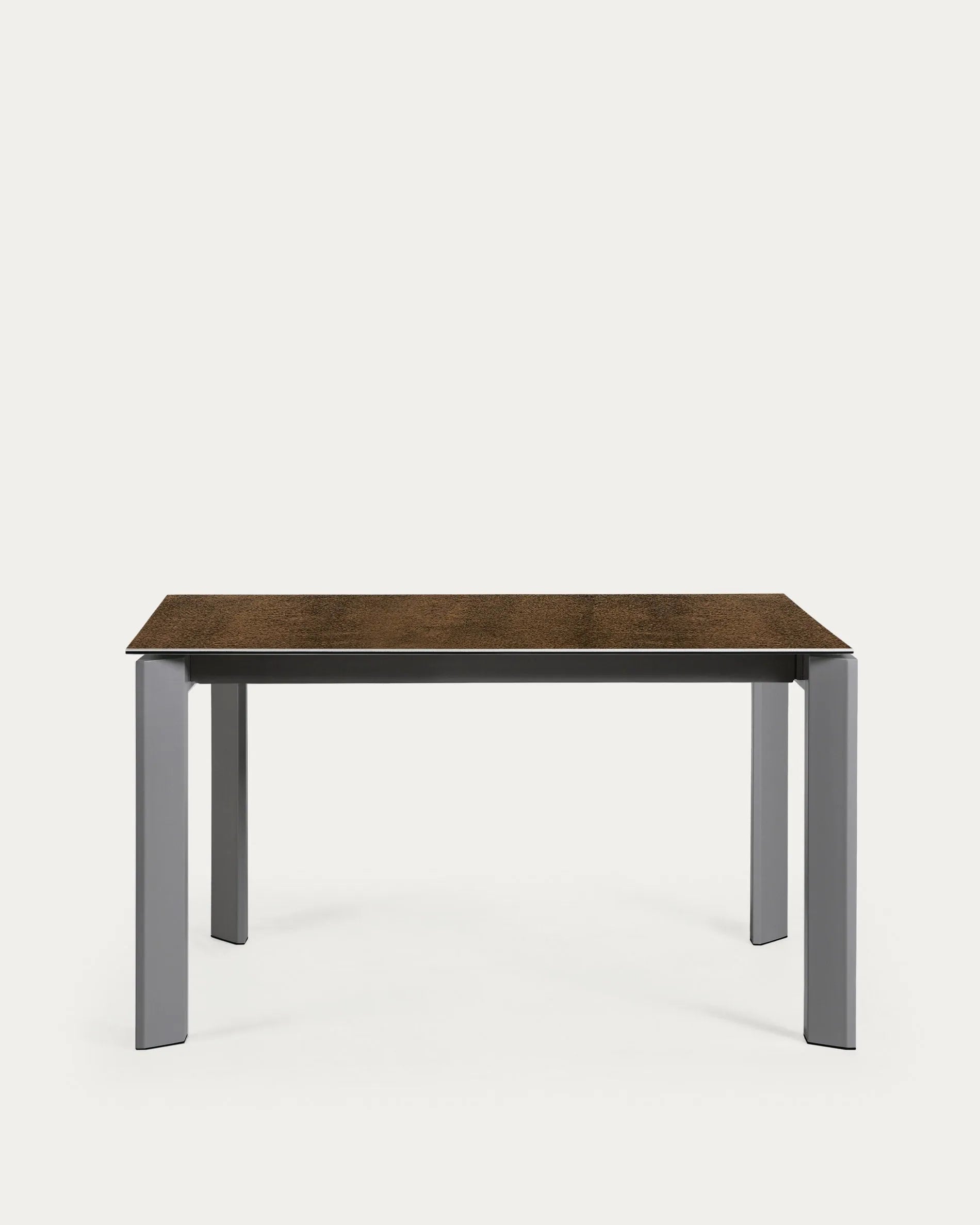 Moderner Ausziehtisch mit robuster Feinsteinzeugplatte im Iron Corten Finish und eleganten, dunkelgrauen Metallbeinen.