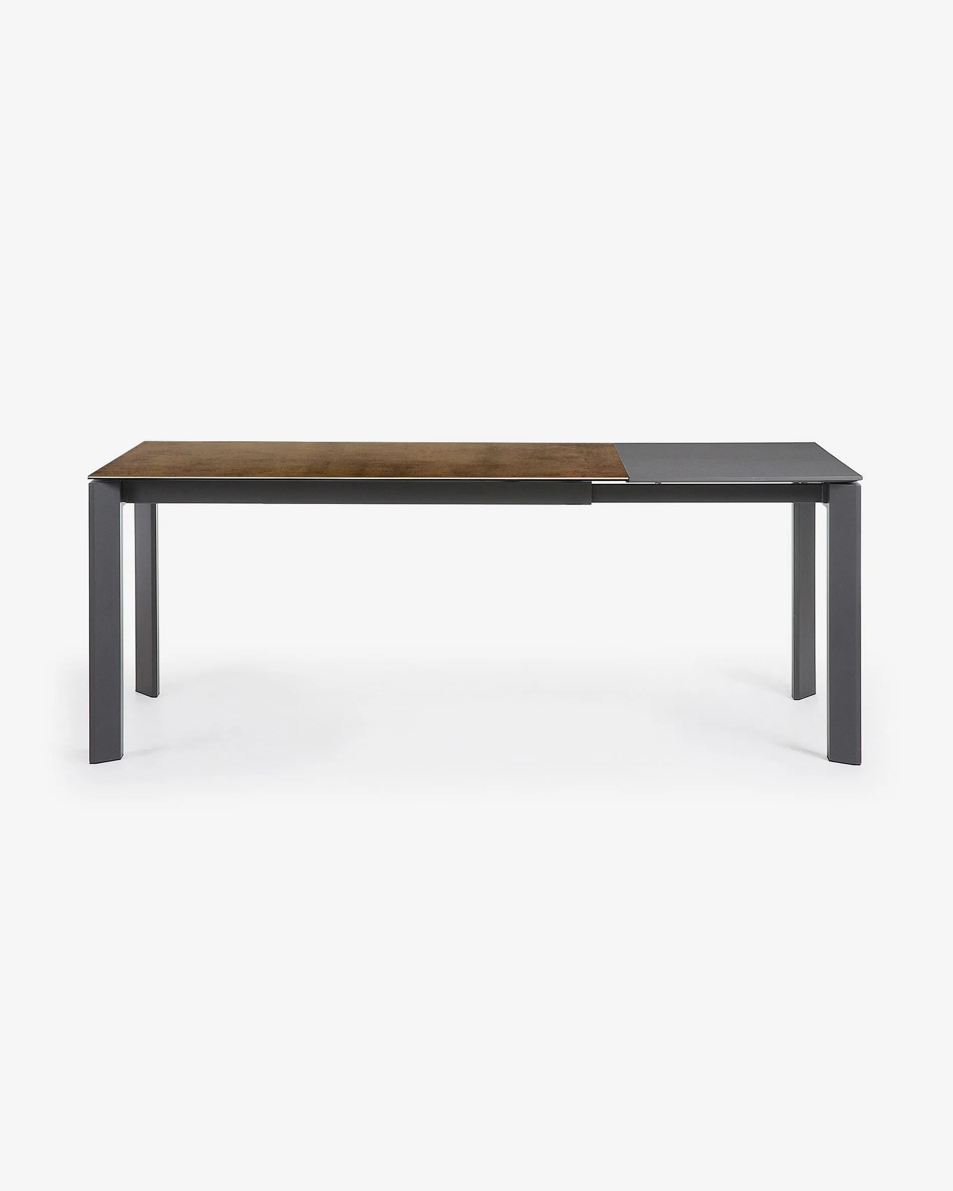 Moderner Ausziehtisch mit robuster Feinsteinzeugplatte im Iron Corten Finish und eleganten, dunkelgrauen Metallbeinen.