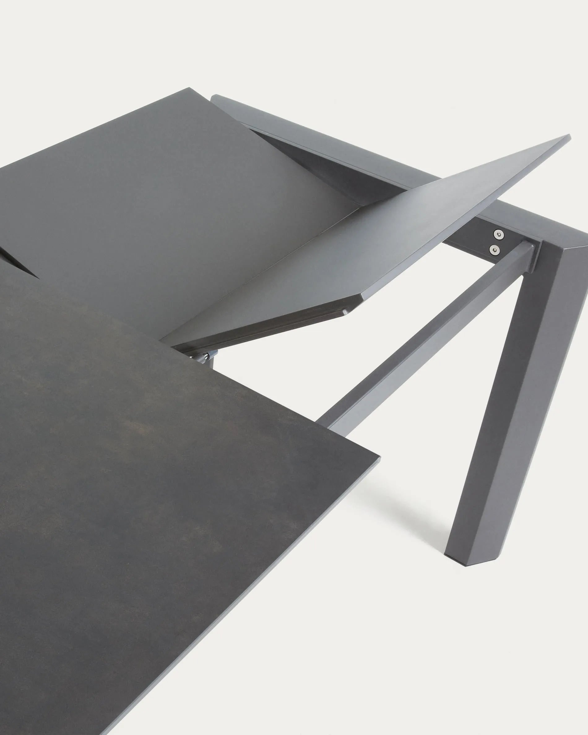Der Axis Ausziehtisch kombiniert modernes Design mit Funktionalität: Feinsteinzeug in Vulcano Roca Finish und stabile Stahlbeine.