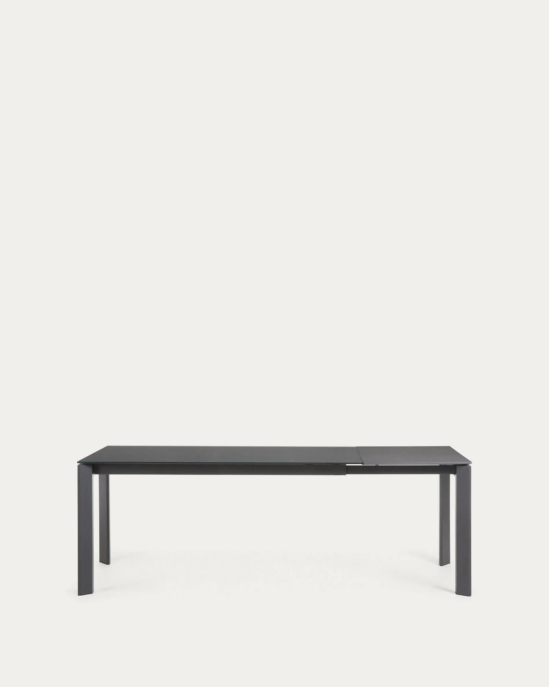 Eleganter Ausziehtisch mit grauer Glasplatte und dunklen Stahlbeinen, flexibel von 160 auf 220 cm erweiterbar.