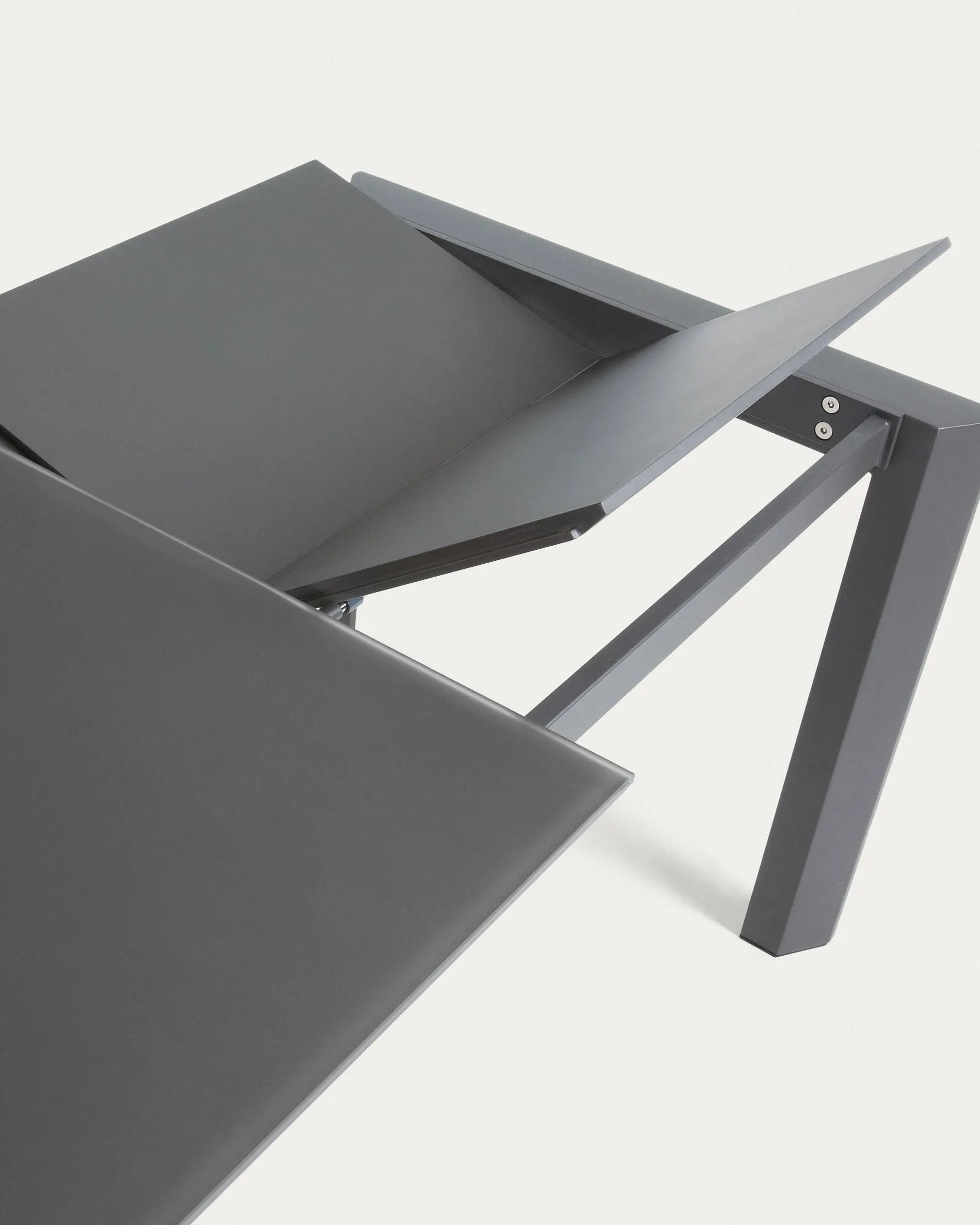 Eleganter Ausziehtisch mit grauer Glasplatte und dunklen Stahlbeinen, flexibel von 160 auf 220 cm erweiterbar.