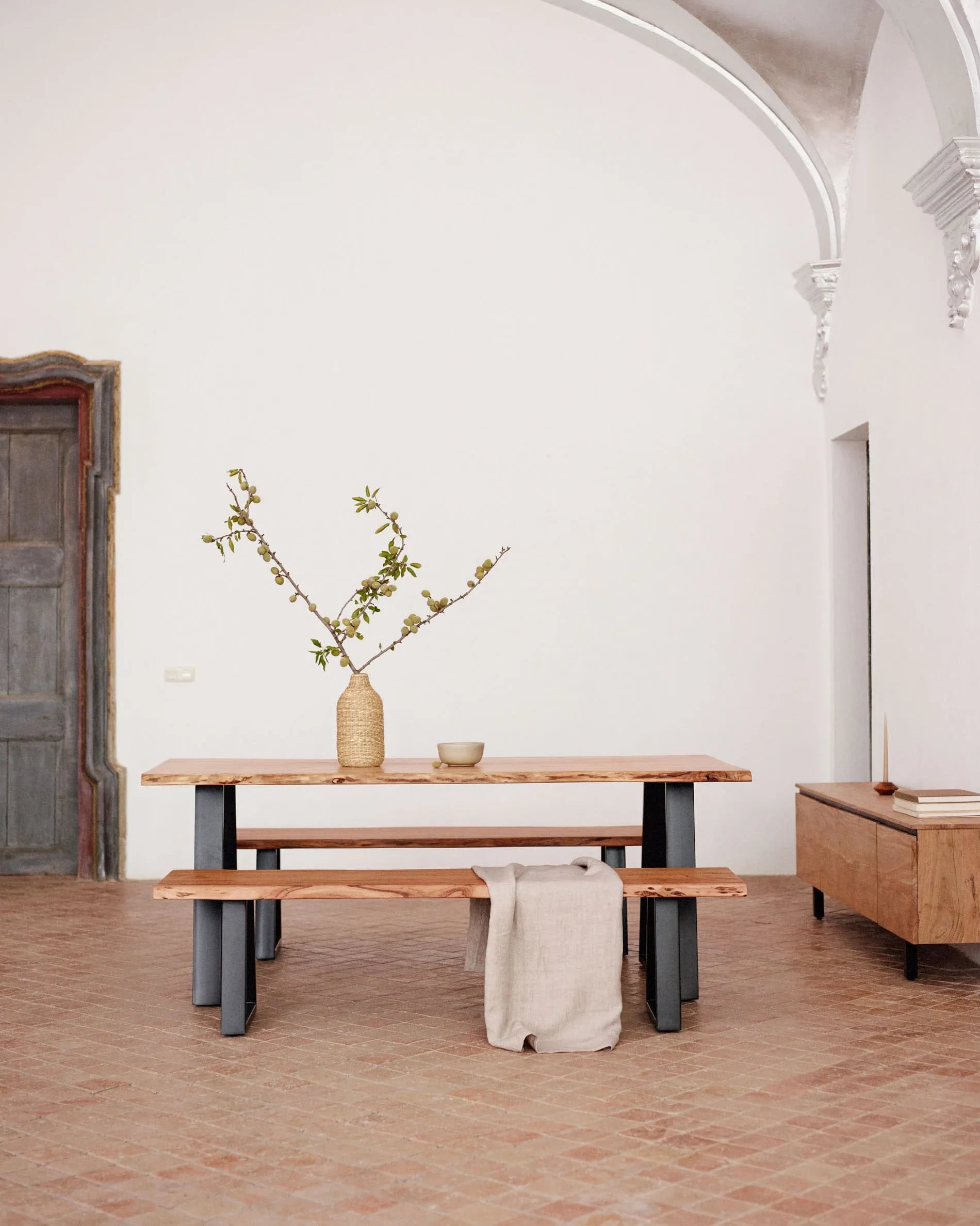 Eleganter Tisch aus Akazienholz mit schwarzen Stahlbeinen, ideal für stilvolle Zusammenkünfte und langlebige Qualität.