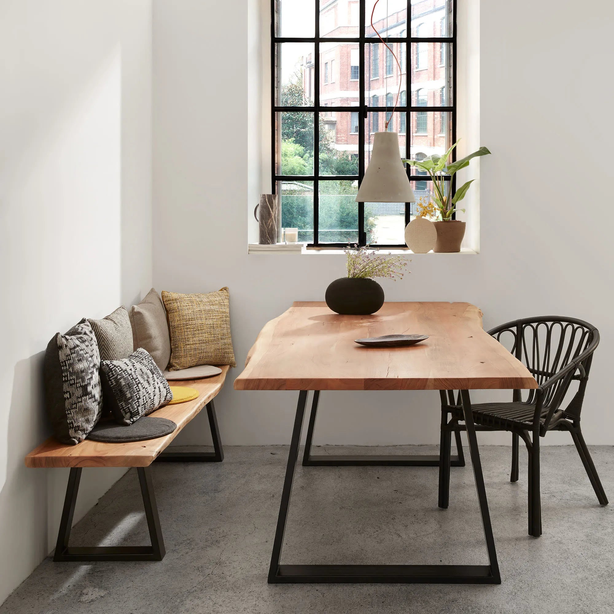 Eleganter Tisch aus Akazienholz mit schwarzen Stahlbeinen, ideal für stilvolle Zusammenkünfte und langlebige Qualität.