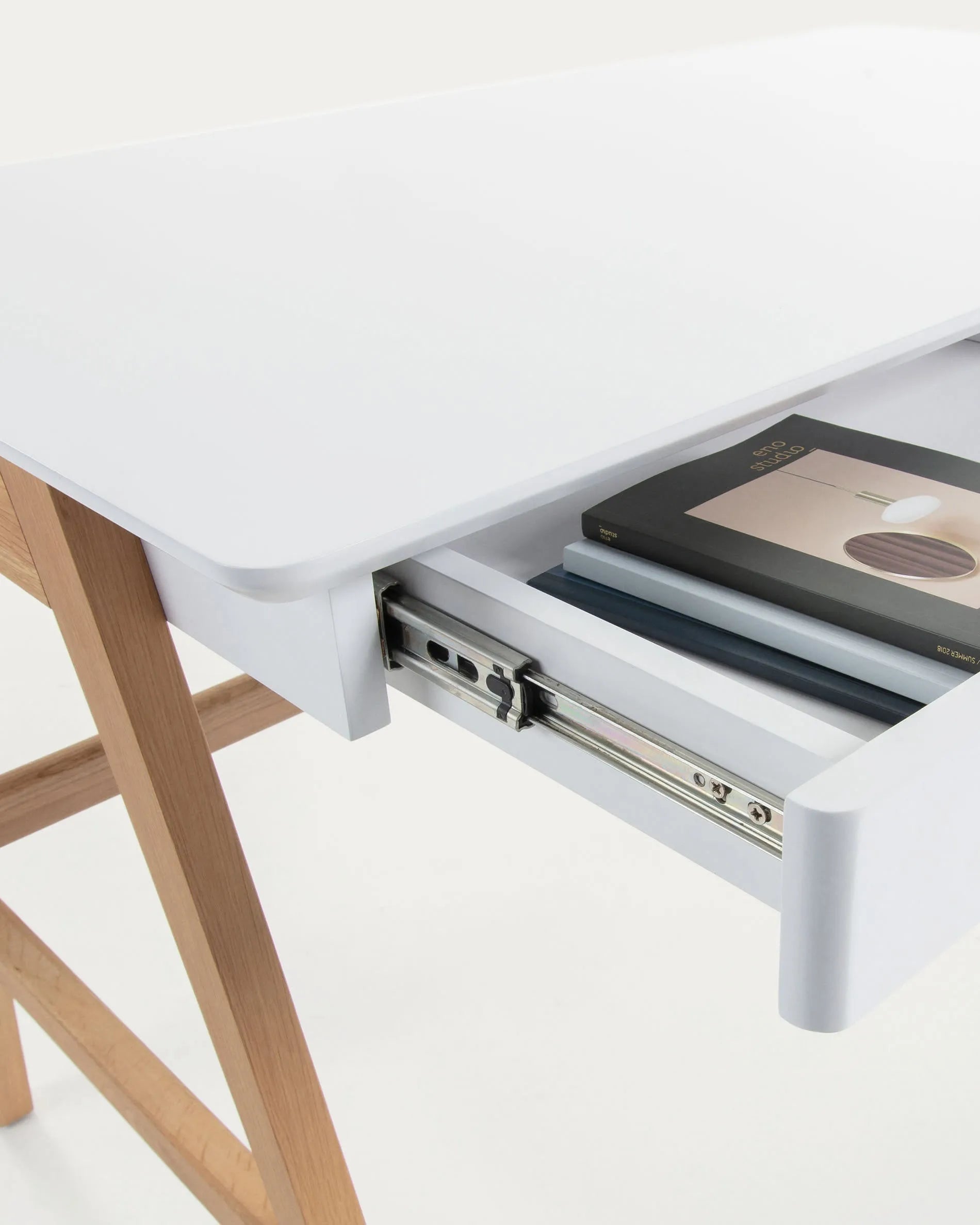 Der Dyana Tisch vereint moderne Eleganz mit Funktionalität: Weiße MDF-Platte trifft auf robuste Eschenholzbeine.