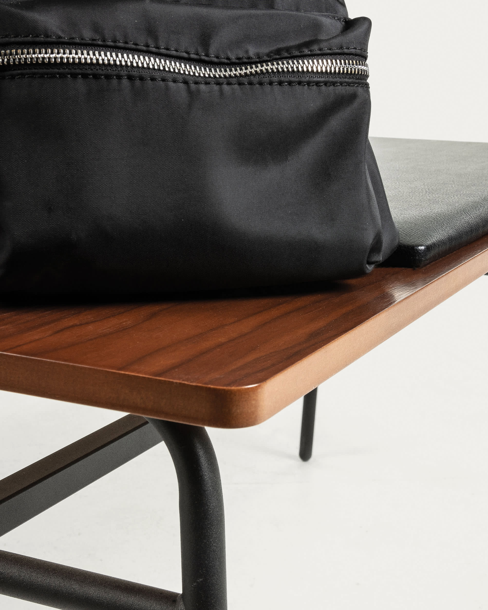 Die Carabel Bank kombiniert robusten Stahl mit edlem Nussholzfurnier und bietet modernes Design auf 100 cm Länge.