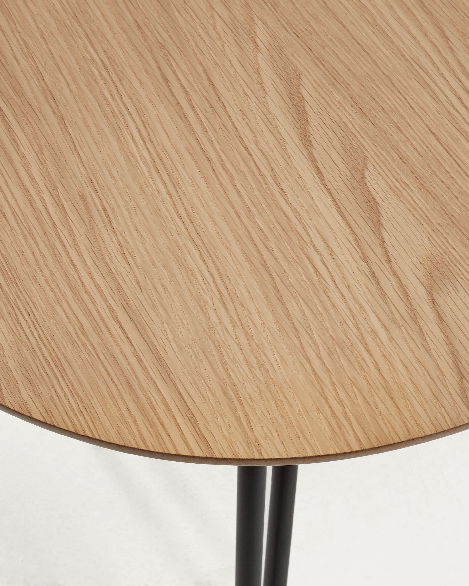 Moderner ausziehbarer Tisch mit Eichenfurnier und schwarzen Stahlbeinen, ideal für stilvolle und funktionale Wohnbereiche.