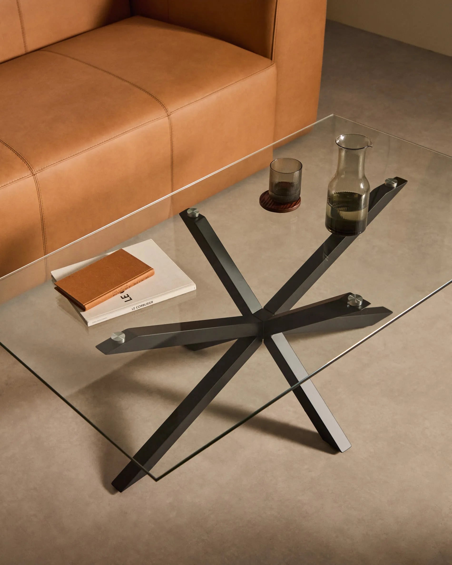 Eleganter Couchtisch mit Glasplatte und schwarzen Stahlbeinen, ideal für moderne Wohnräume.