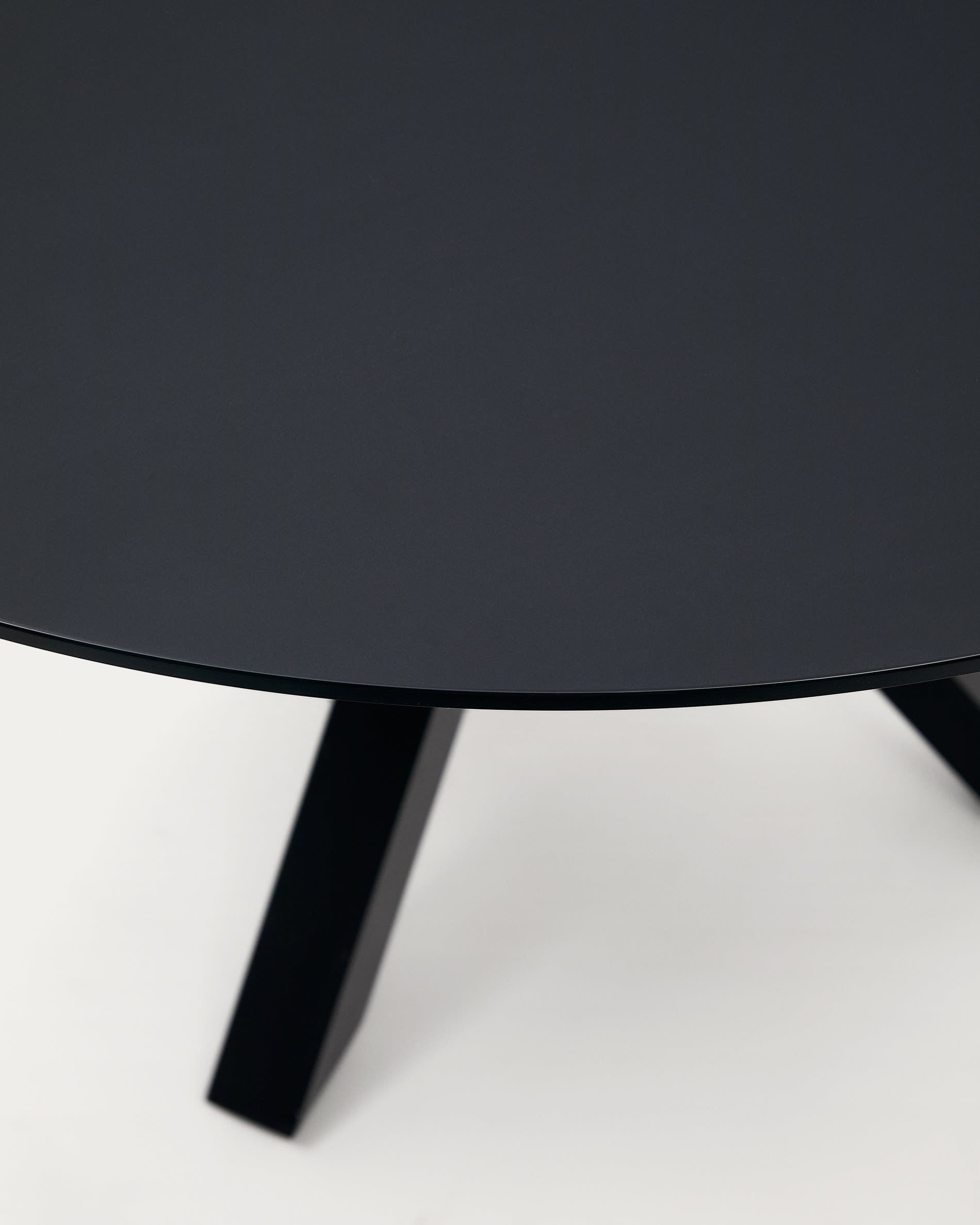 Moderner runder Tisch Argo, Ø 120 cm, mit stilvoller schwarzer Glasplatte und stabilen schwarzen Stahlbeinen, perfekt für zeitgemäßes Design.