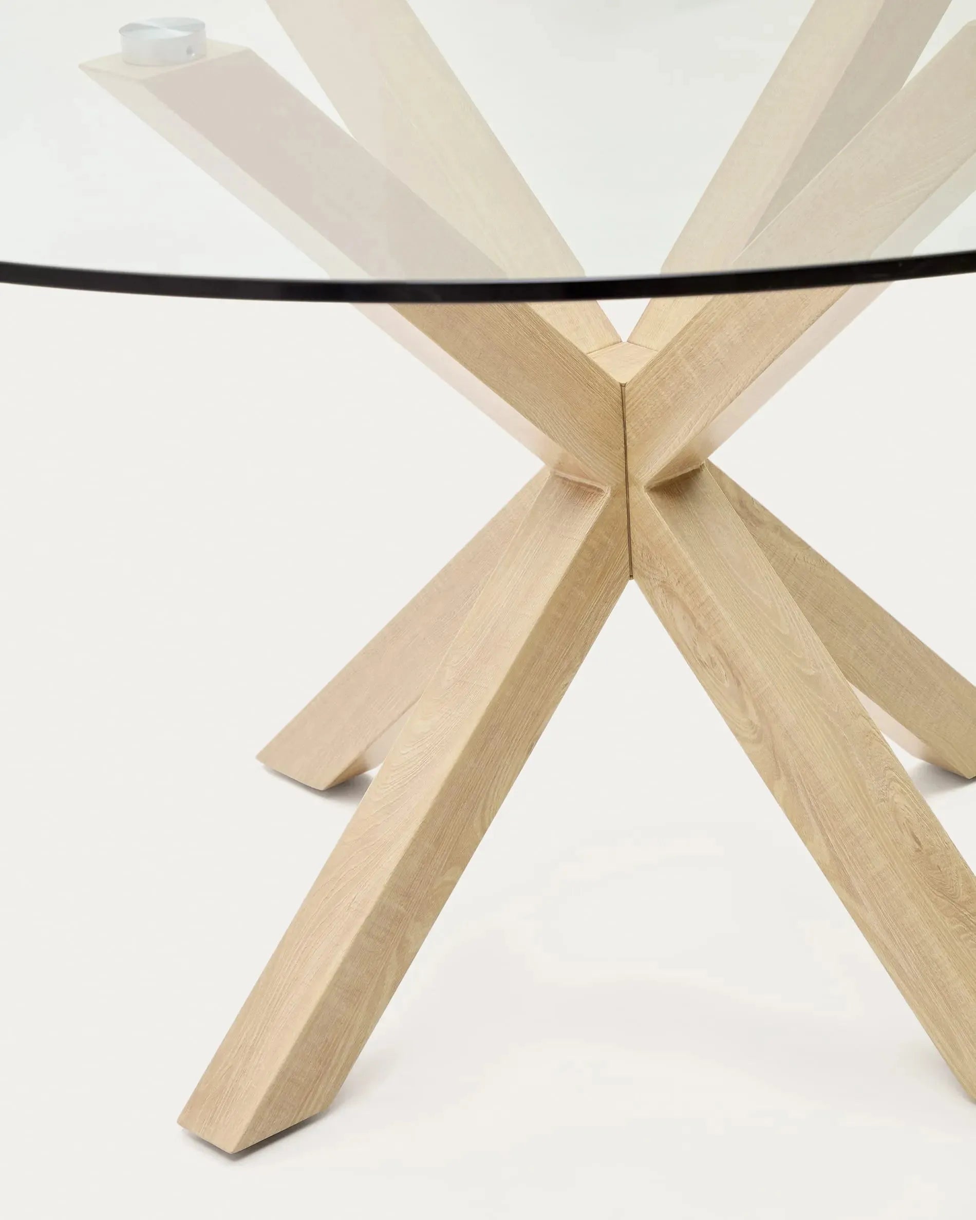 Eleganter runder Glastisch Argo von Kave Home, Ø 150 cm, mit robusten Stahlbeinen in Holzoptik, perfekt für moderne Wohnräume.